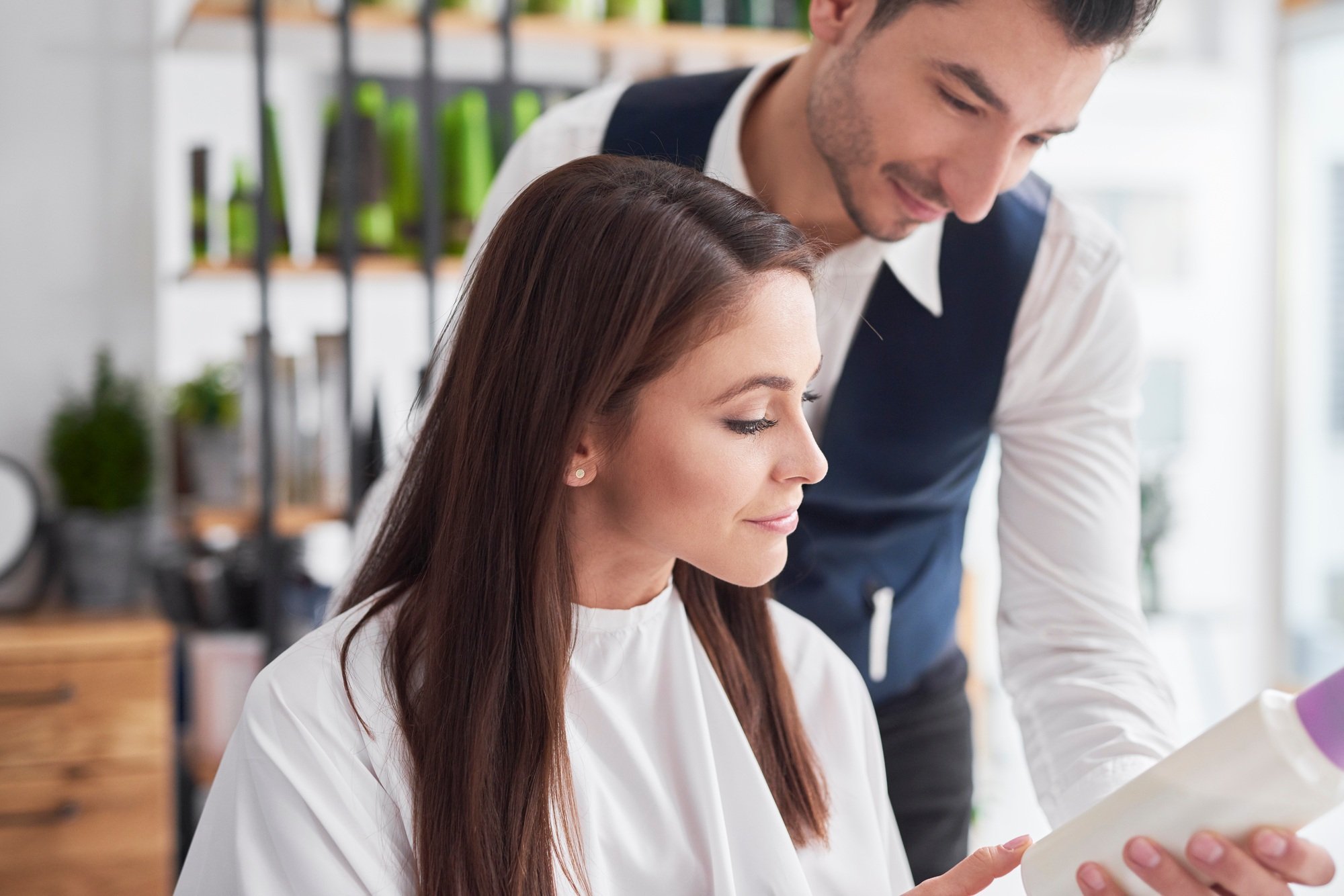 Hairstylist and female customer talking in hair salon