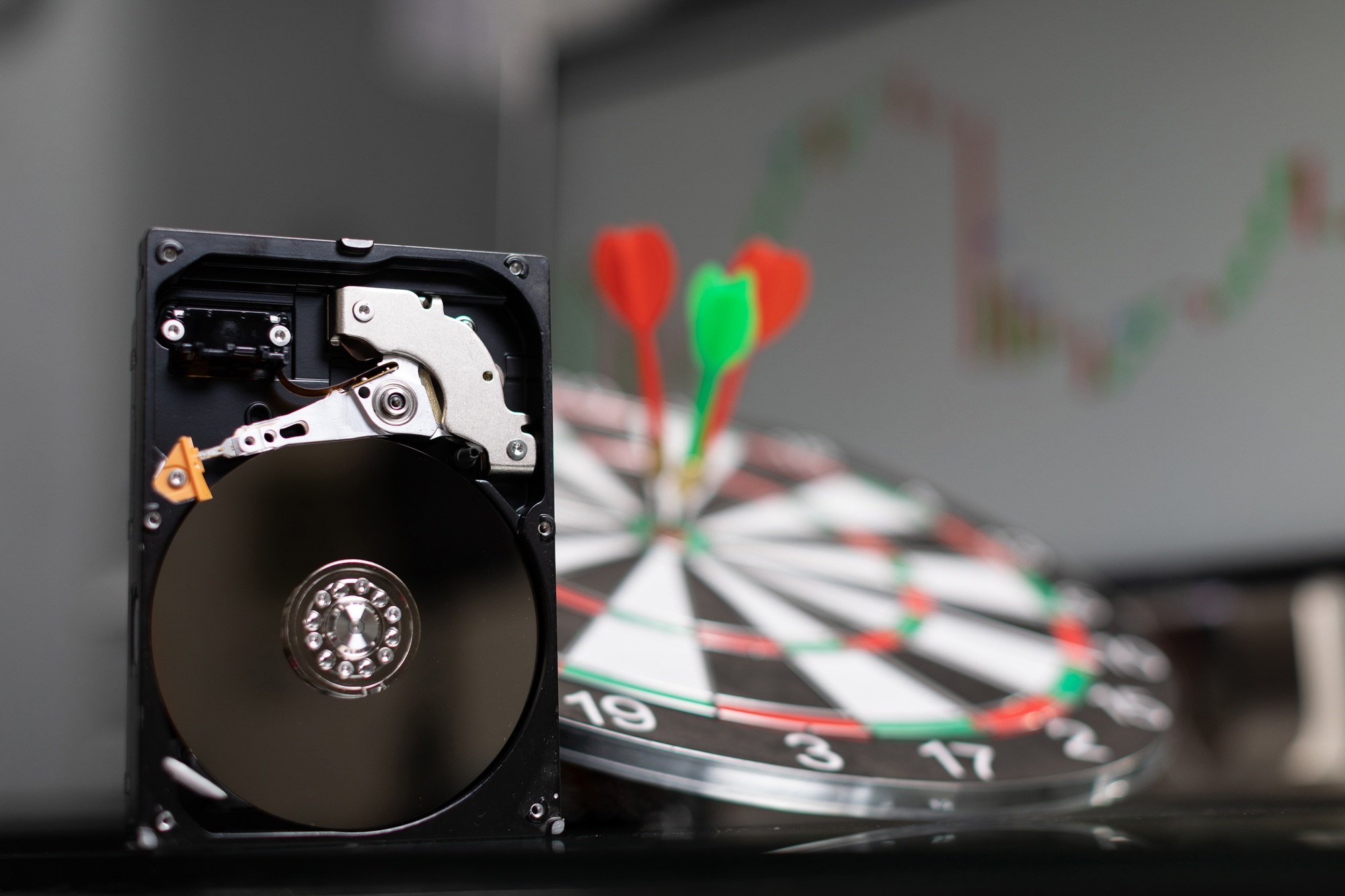 hard drive in background of dart Board with Darts at targets and graphics