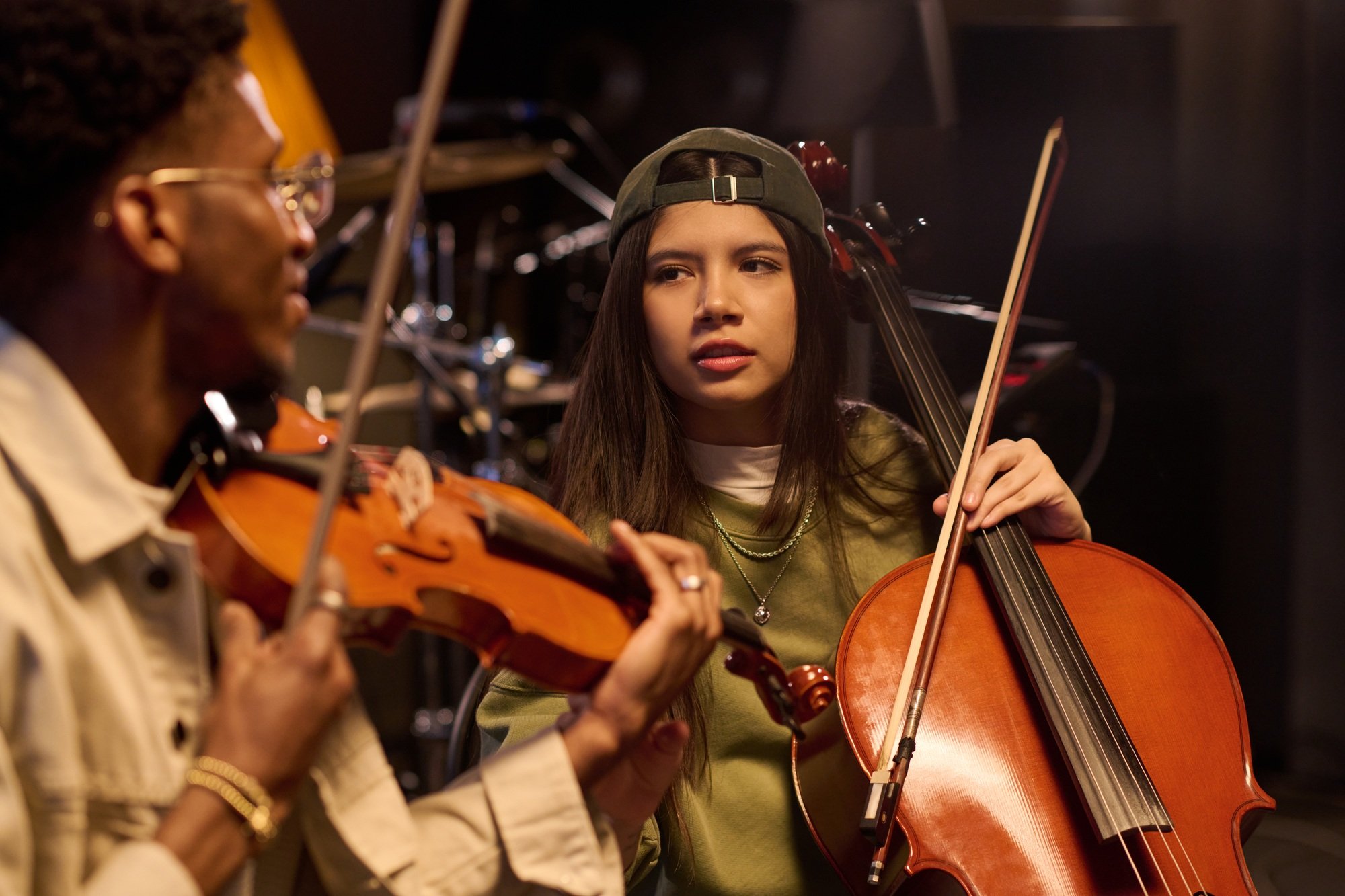 Hispanic Girl Playing Cello with Young Adult Black Man Playing Violin