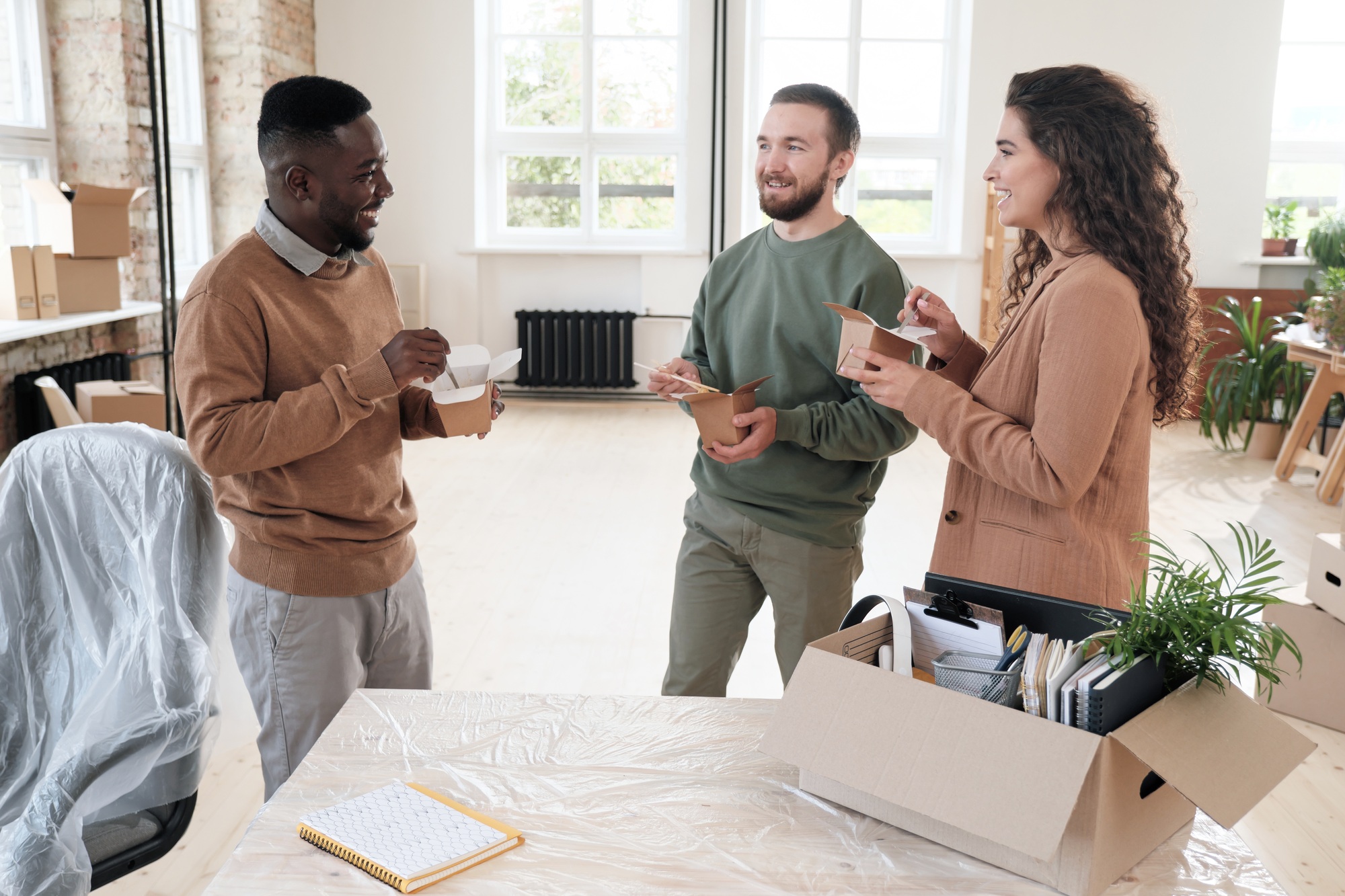 Positive employees chatting during lunch break in office