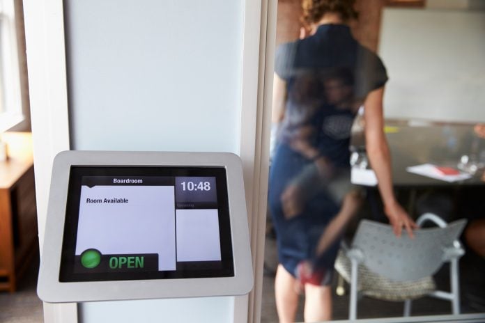 Screen Of Digital Tablet Booking System Outside Modern Boardroom