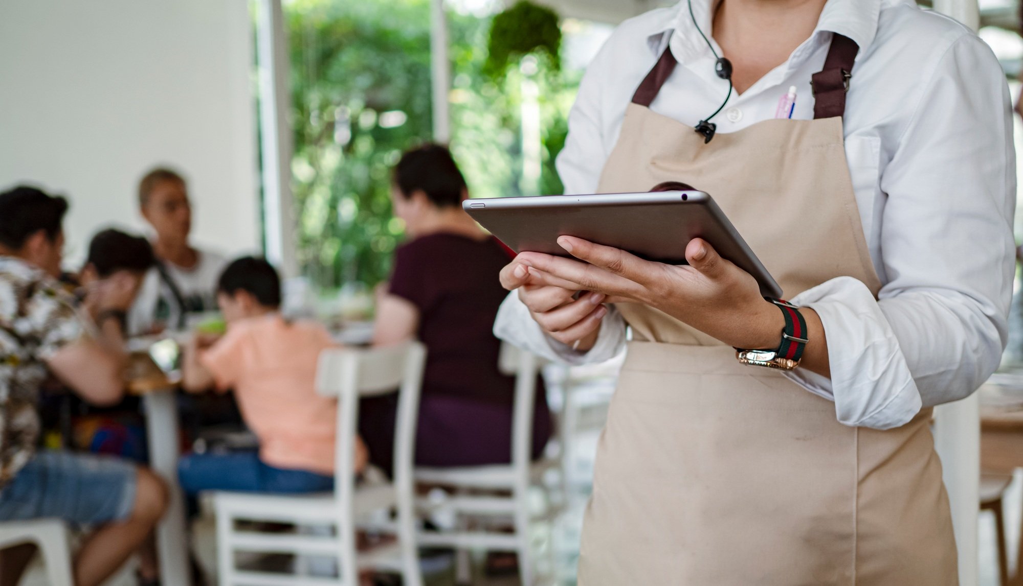 Service waiter servicing the customer at cash point in cafe.