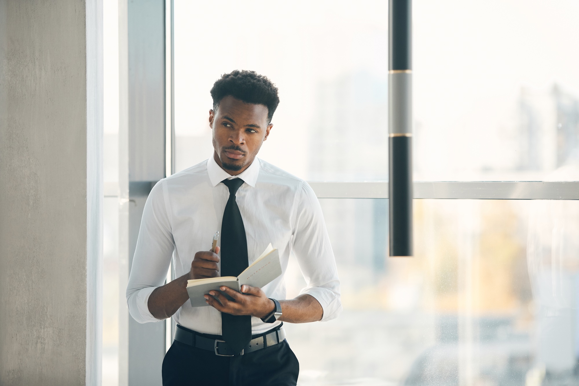 Thoughtful black manager writing down ideas