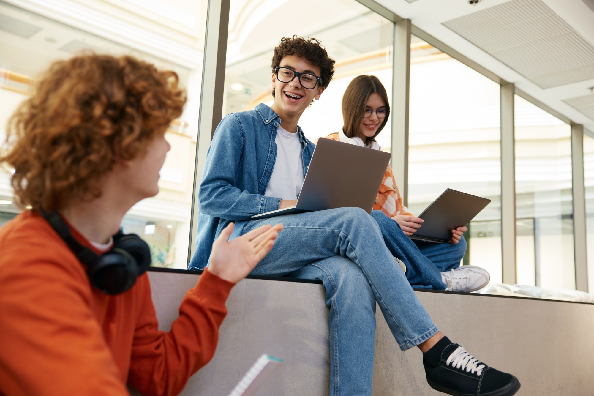 Three young workers making money online using their laptops in modern office