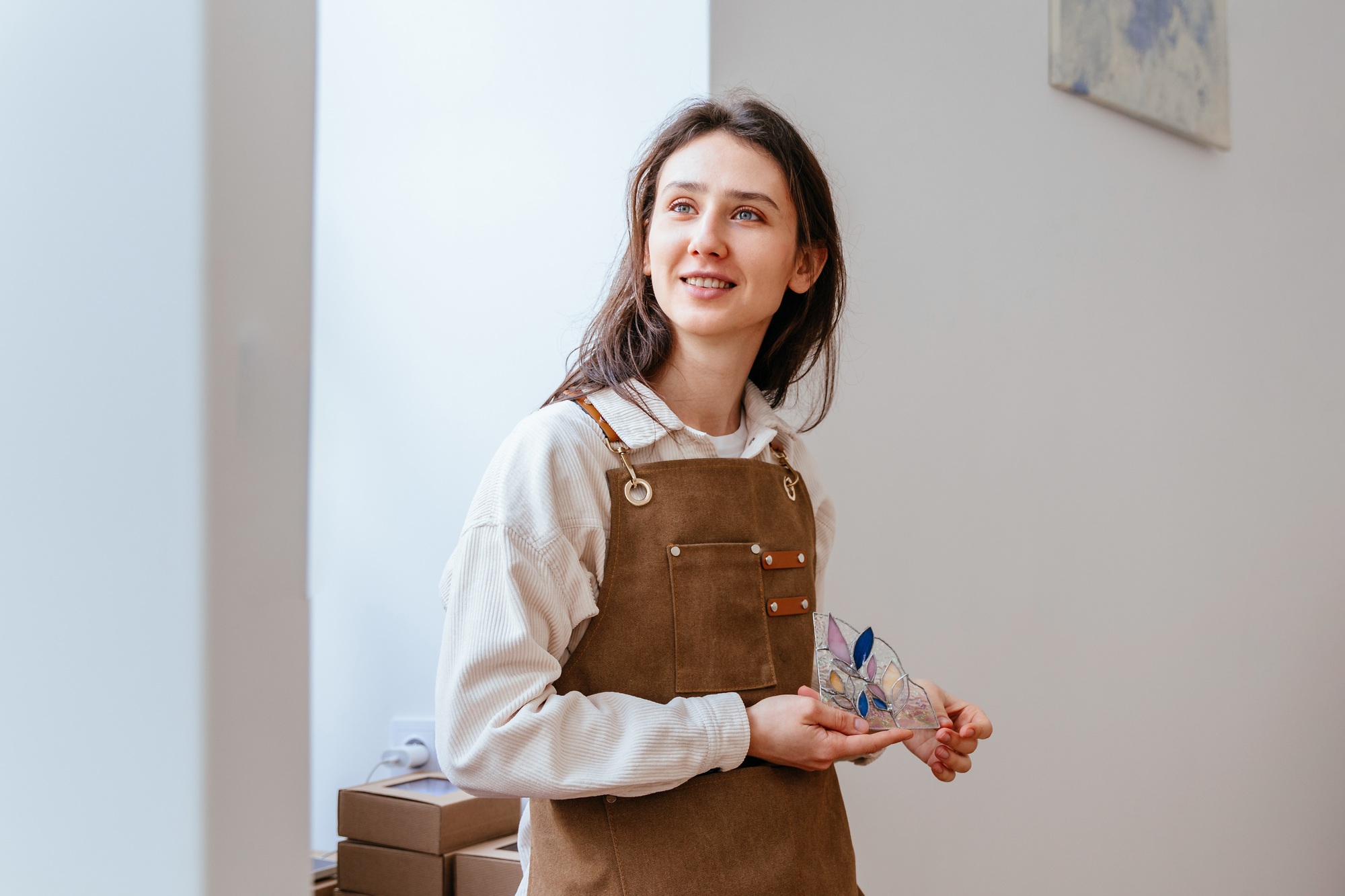 woman stained glass artist holding examples of her work. Small business, arts and crafts concept.