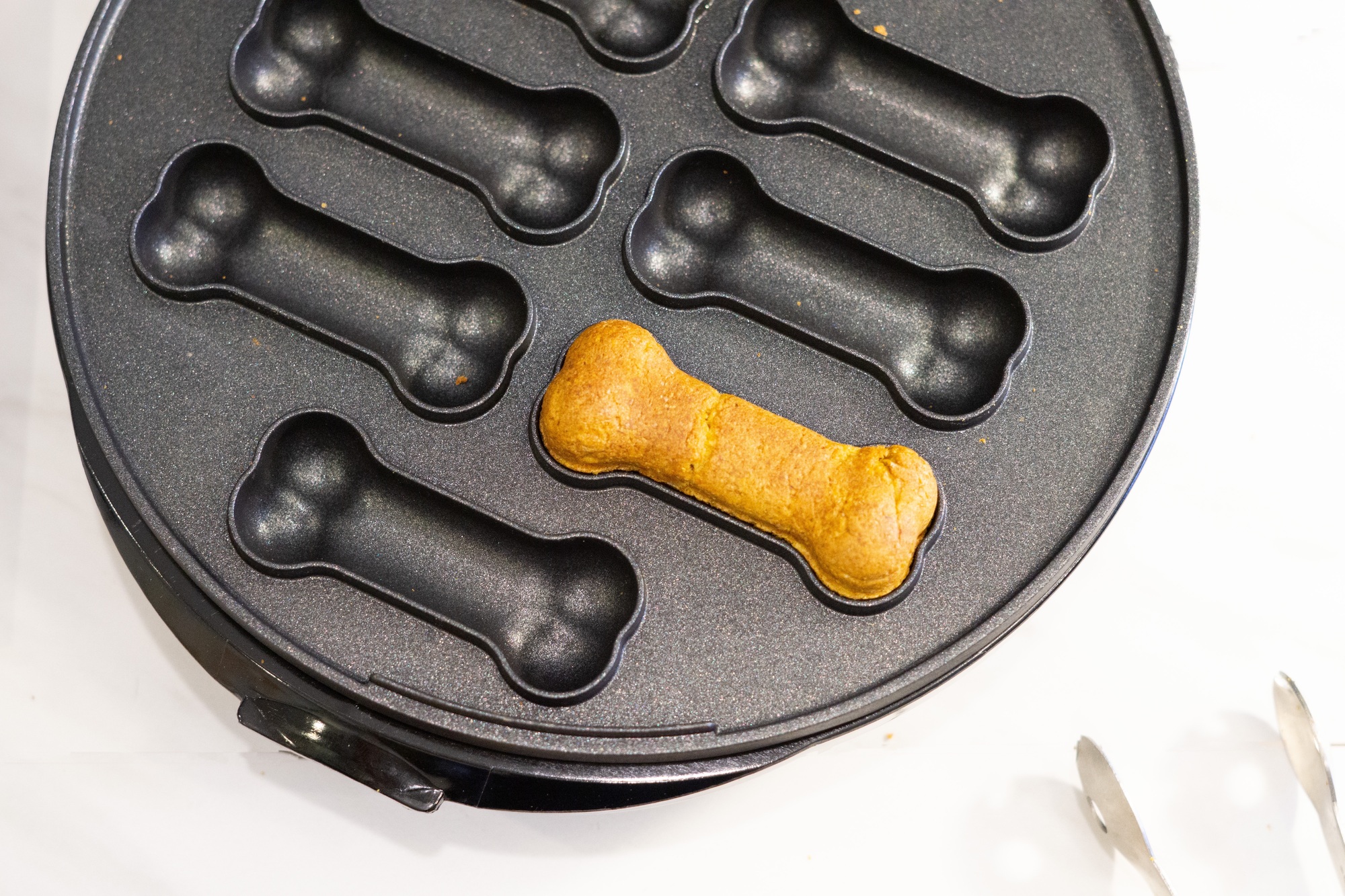 A freshly baked dog treat in a dog treat maker