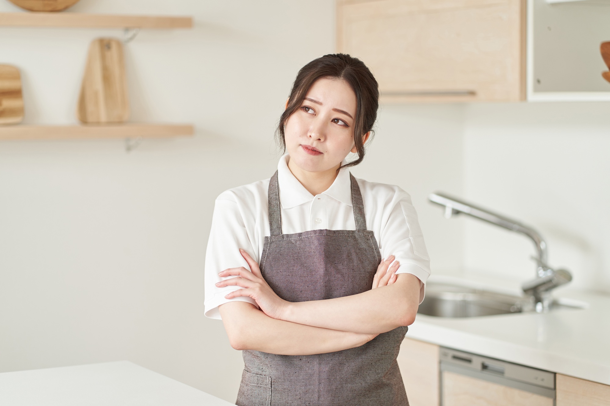 A woman in the housekeeping business who crosses her arms and thinks
