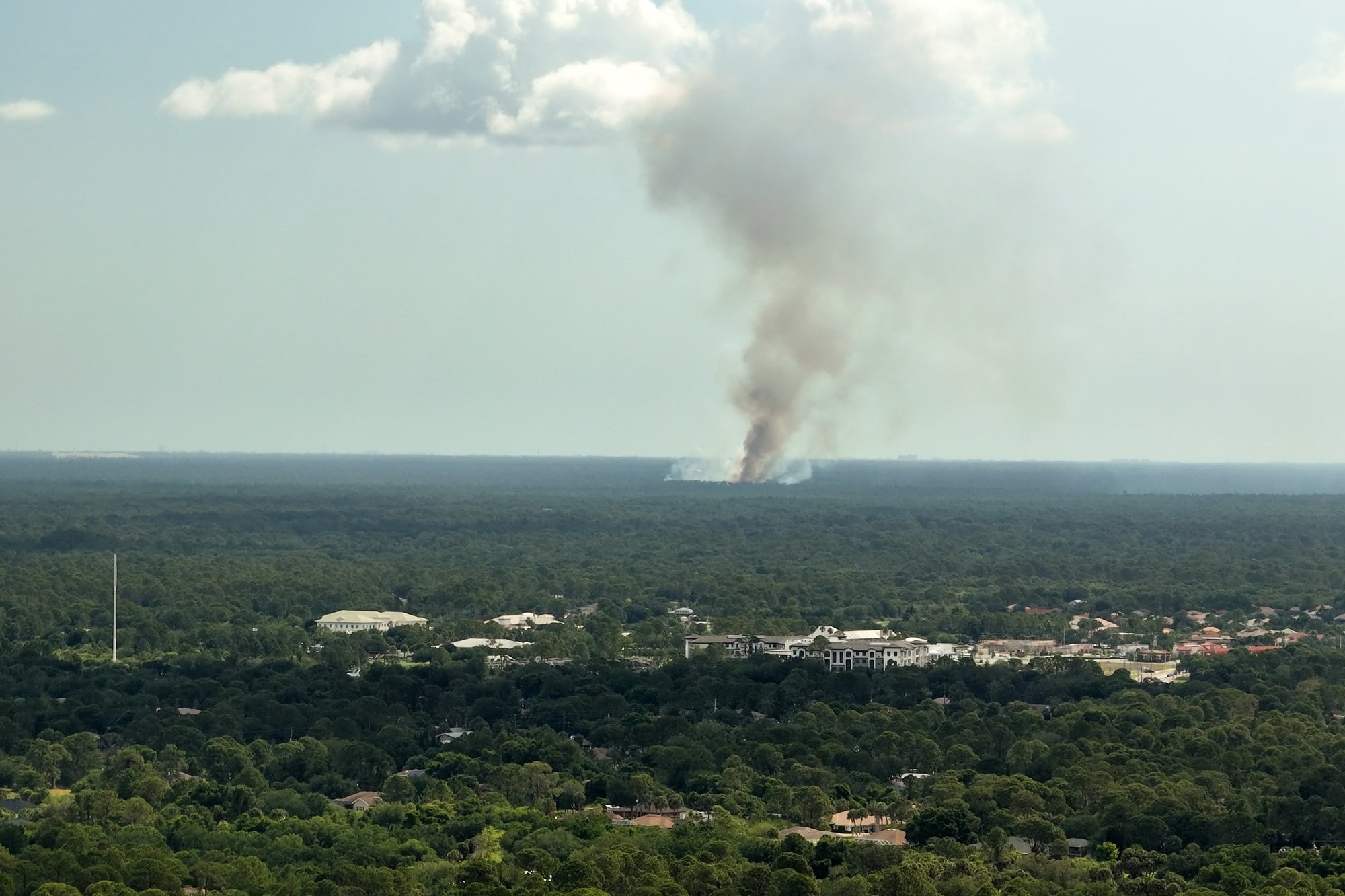 Aerial view of large wildfire burning severely in Florida jungle woods.