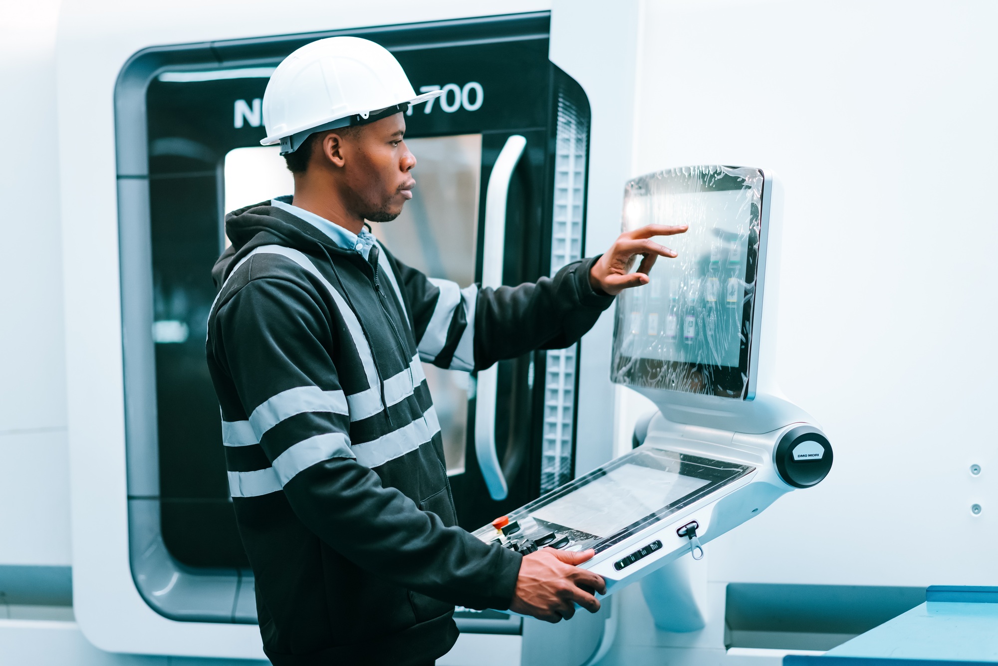 African american man specialist engineer using controller monitor for controlling robotic arm