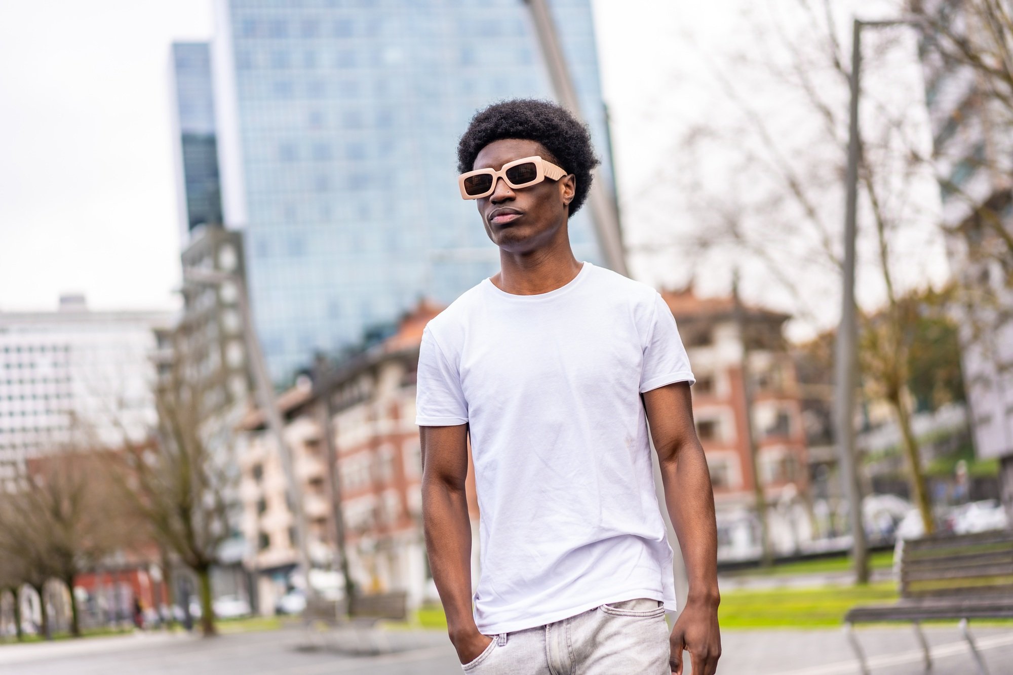 African man in white clothes walking along the city