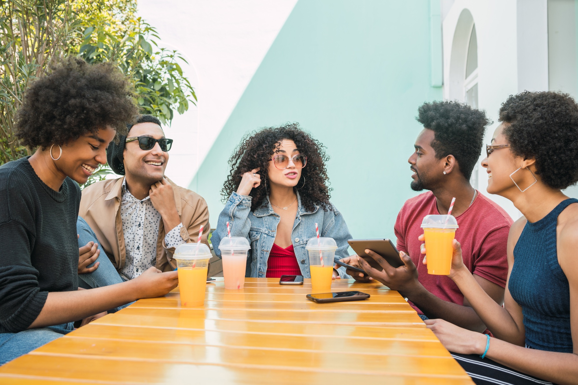 Afro friends having fun together while drinking fruit juice.