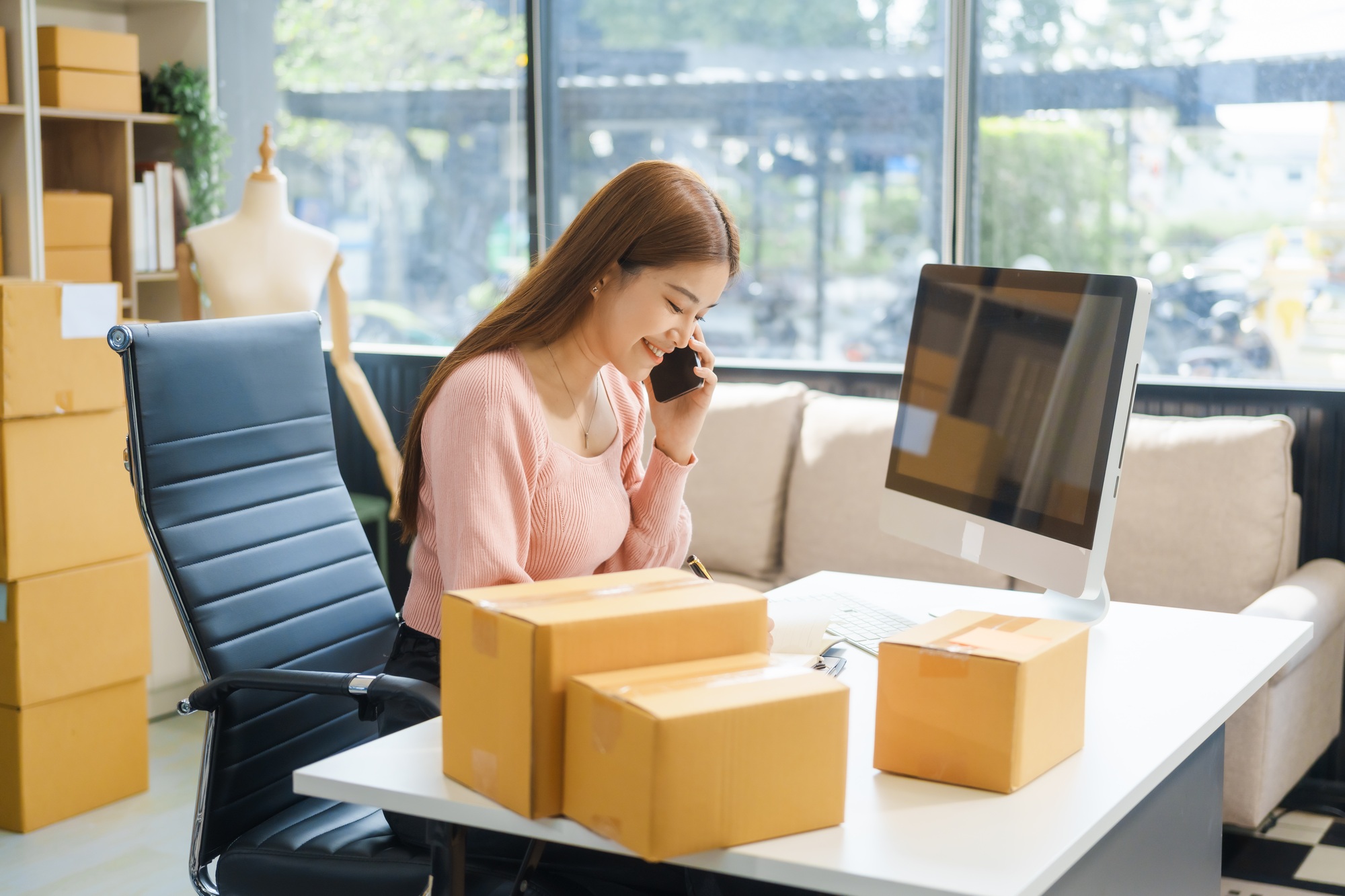 An Asian businesswoman sits at her desk, working on online sales  e-commerce marketing strategies