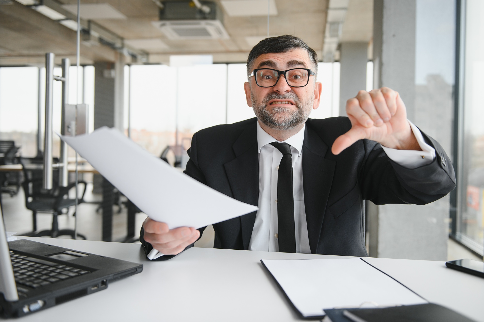 Angry boss behind of office table