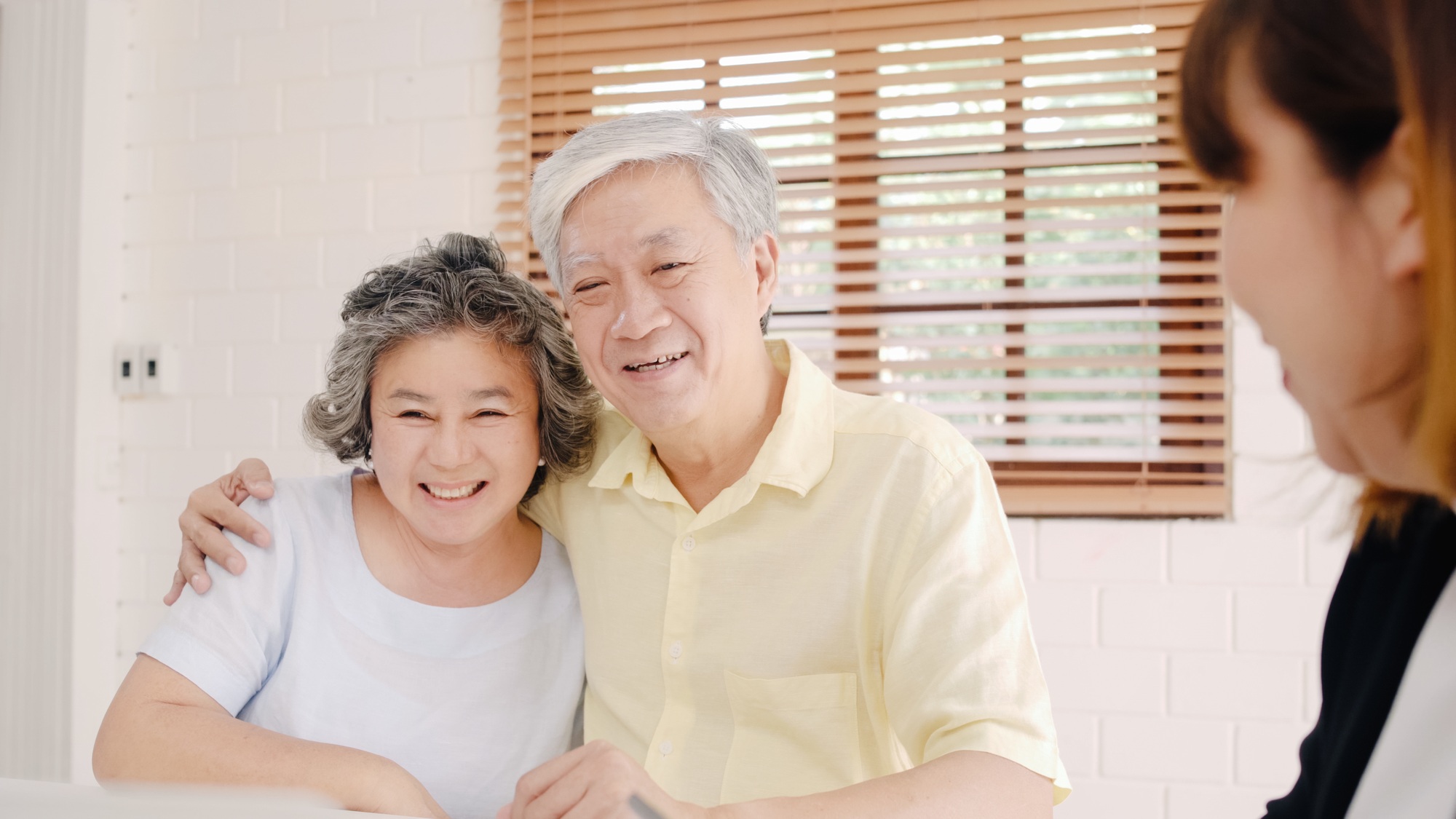 Asia smart female agent offers health insurance for elderly couples by document.