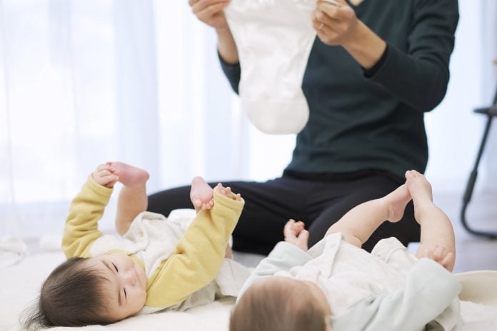 Asian dad changing baby diapers