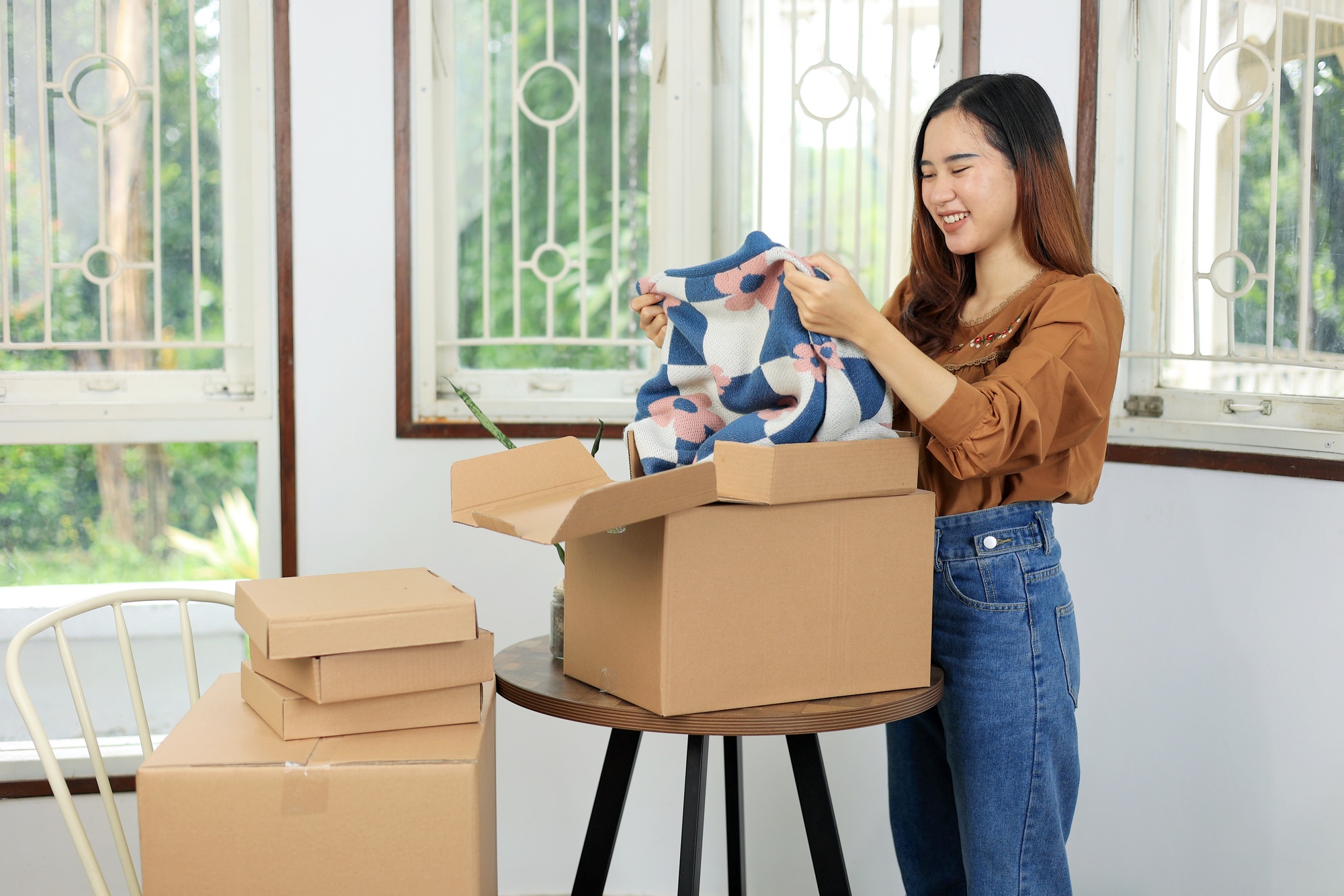 Asian Female Unboxing Product from Marketplace with Happy Face.