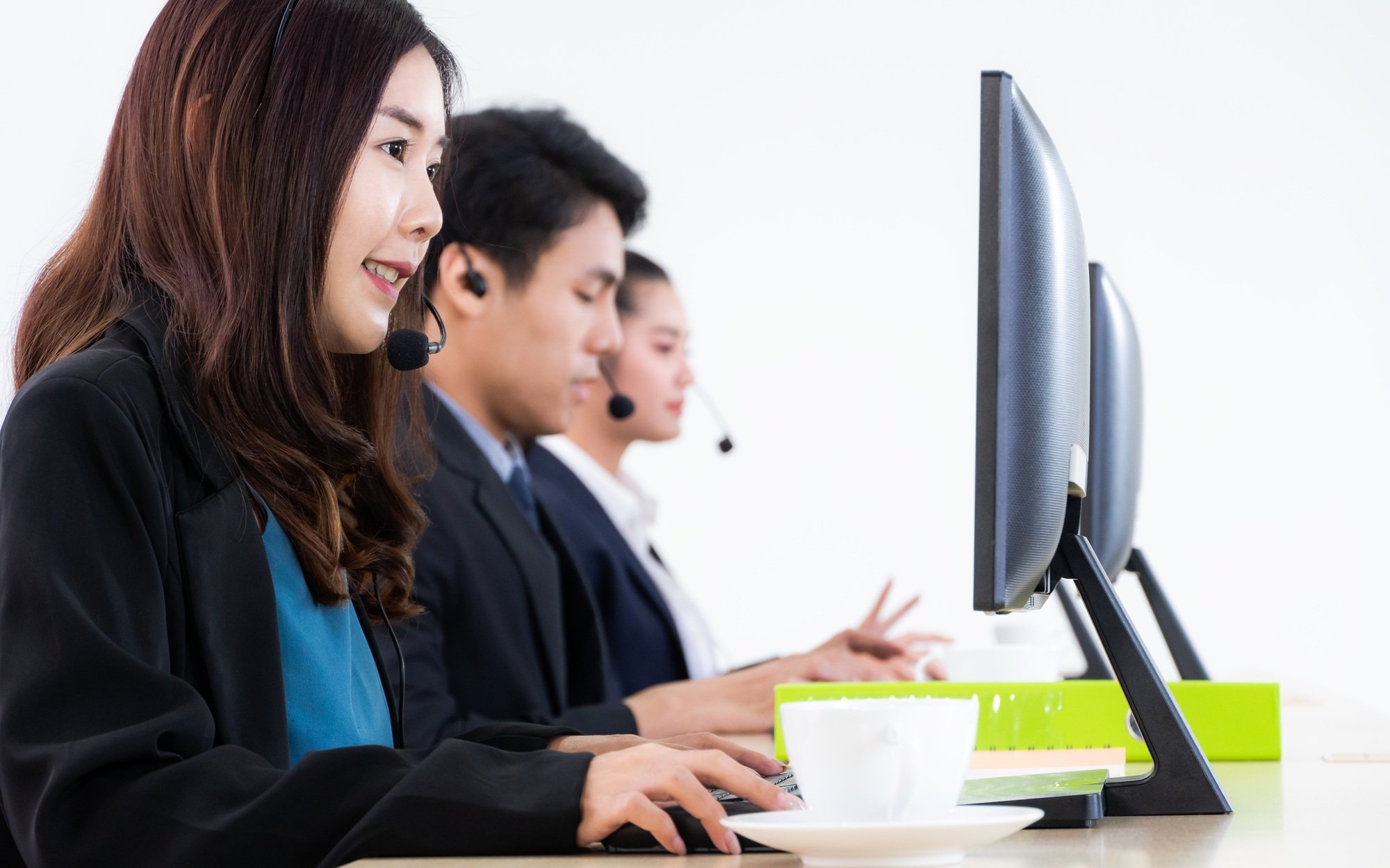 Asian support team working at desk in an office