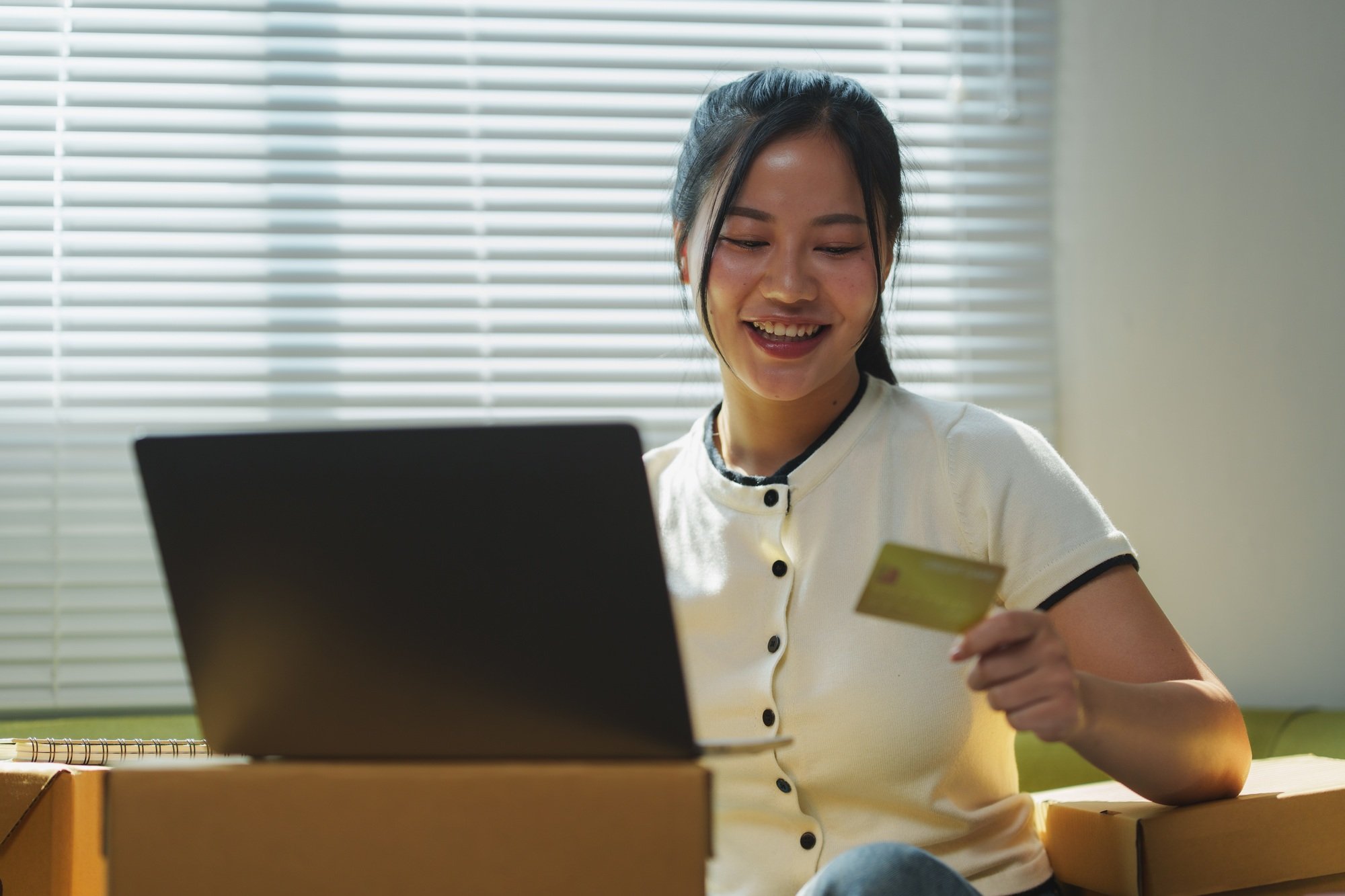 Asian woman paying online with credit card, doing ecommerce at home