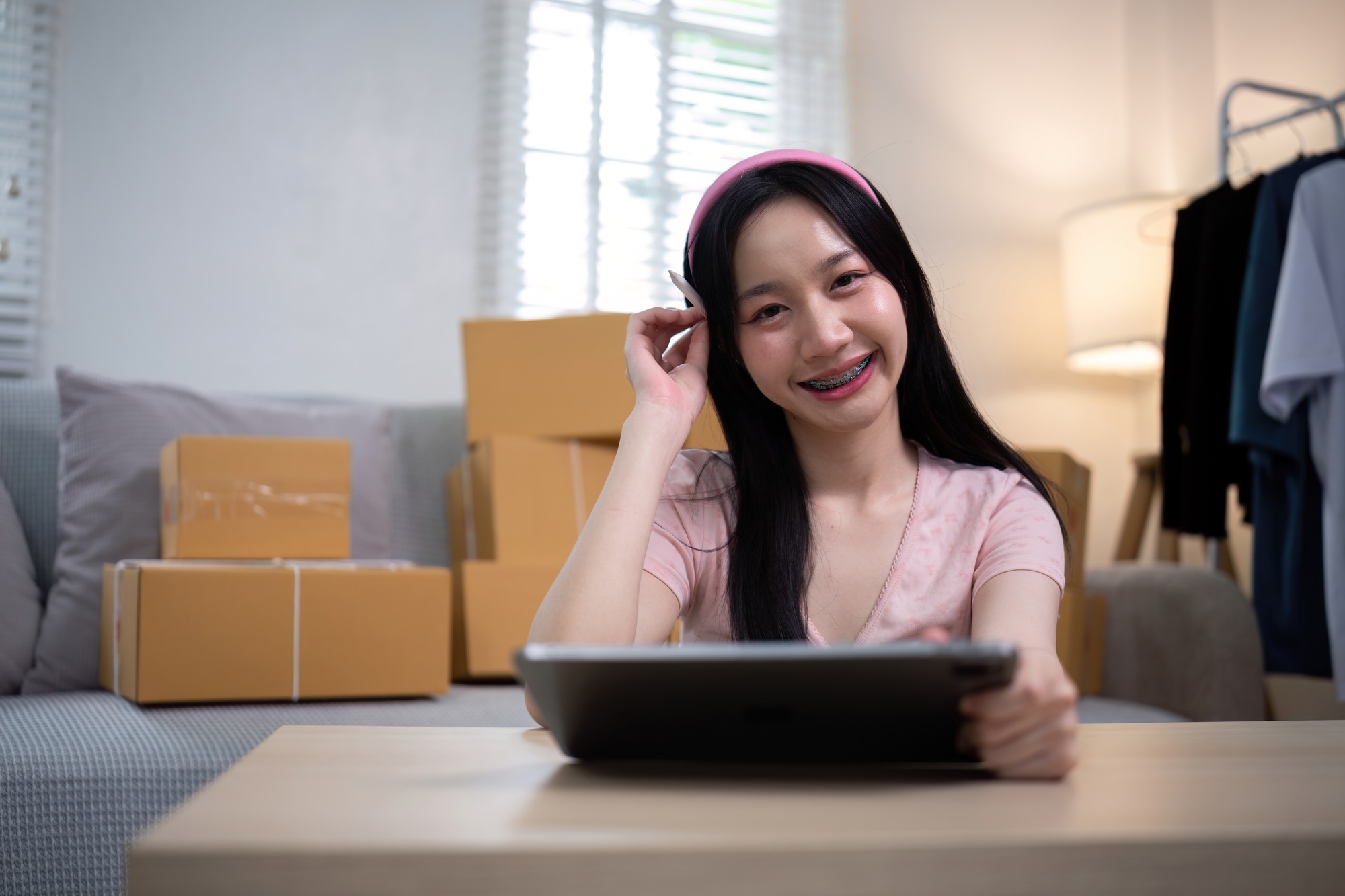 Asian woman small business entrepreneur working from home use tablet for commercial inspection