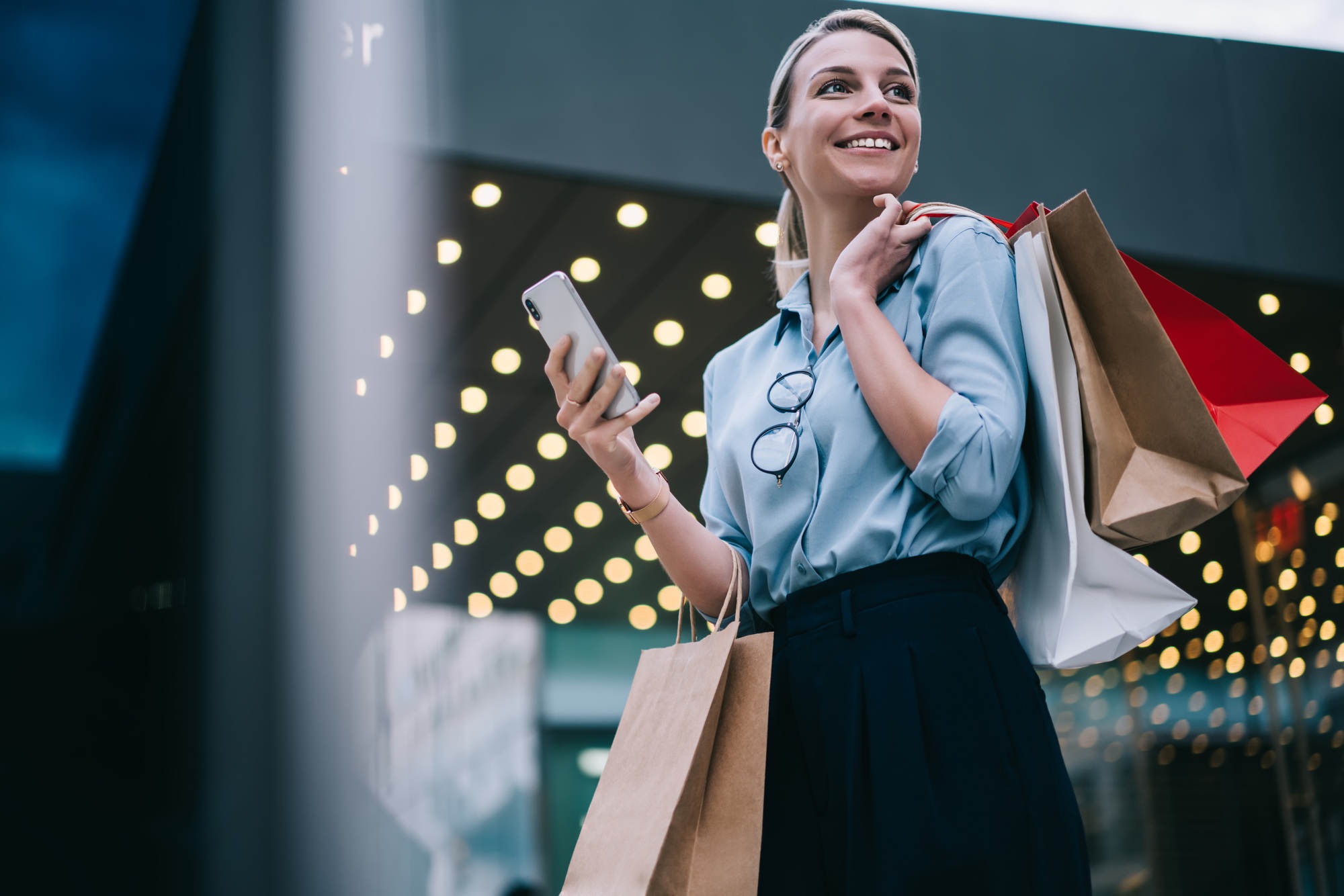 attractive smiling female standing outdoors enjoying leisure time in shopping mall area