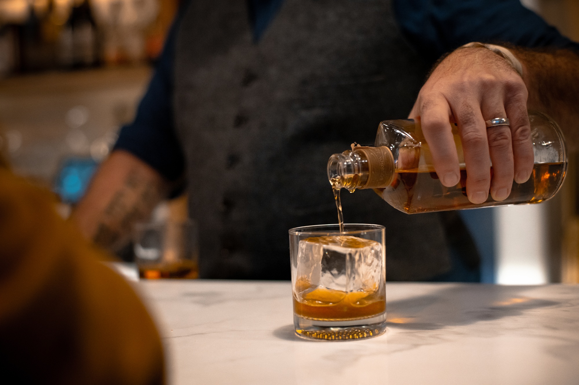 Bartender pouring a whiskey for his costumer