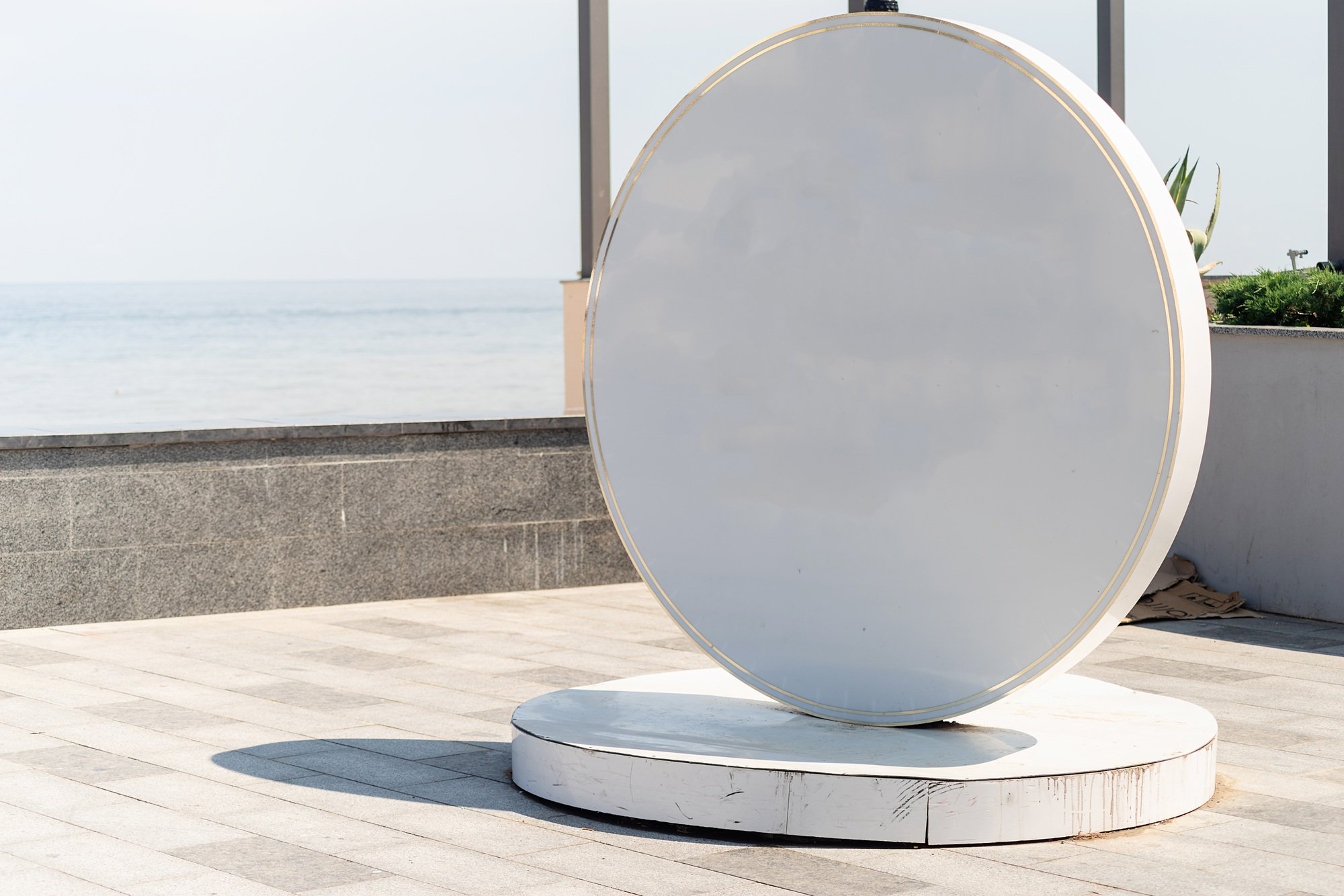 Blank white sign for logo located by the sea on the embankment. Mockup design