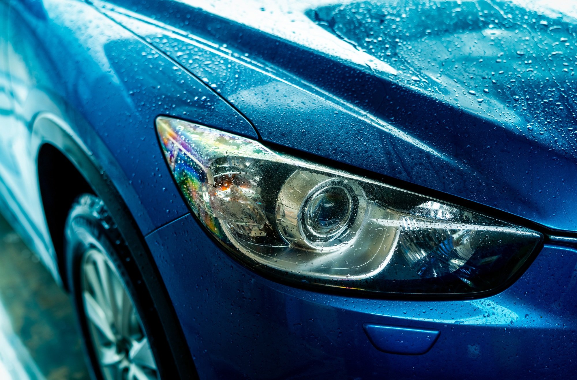 Blue car is washing with water. Auto care business. Car with drops of water after cleaning