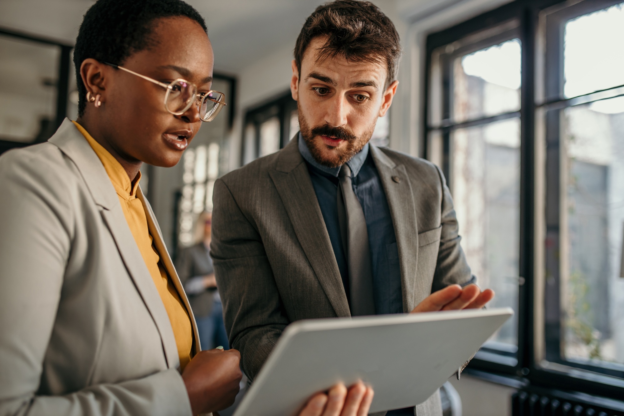 Business colleagues sharing worried look at digital tablet in office