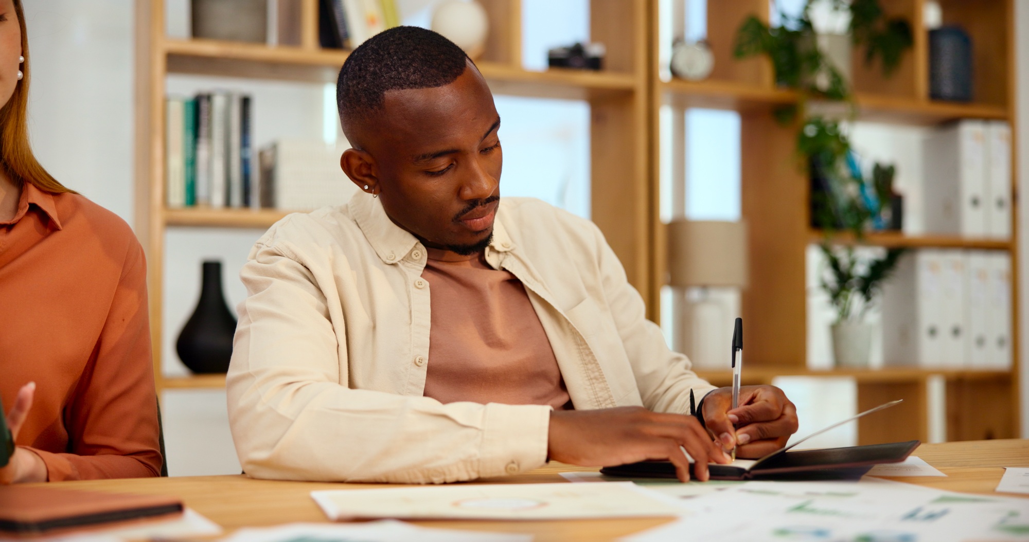 Business, man and writing notes in meeting with financial planning, budget update and investment s