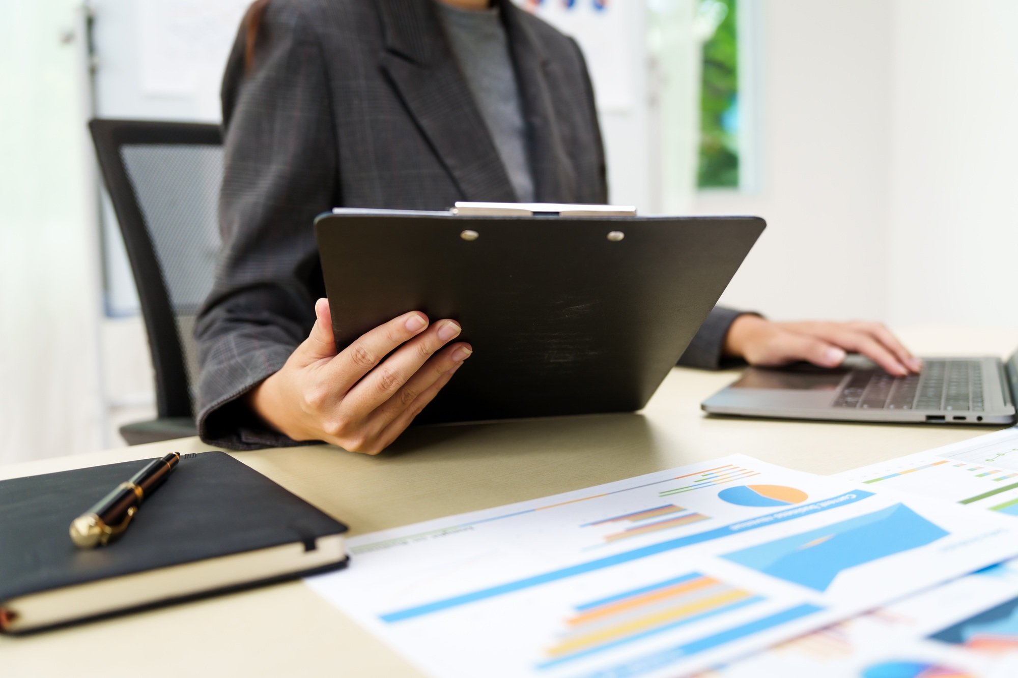 Businesswoman in a grey suit works from home, specializing in policy and planning analysis