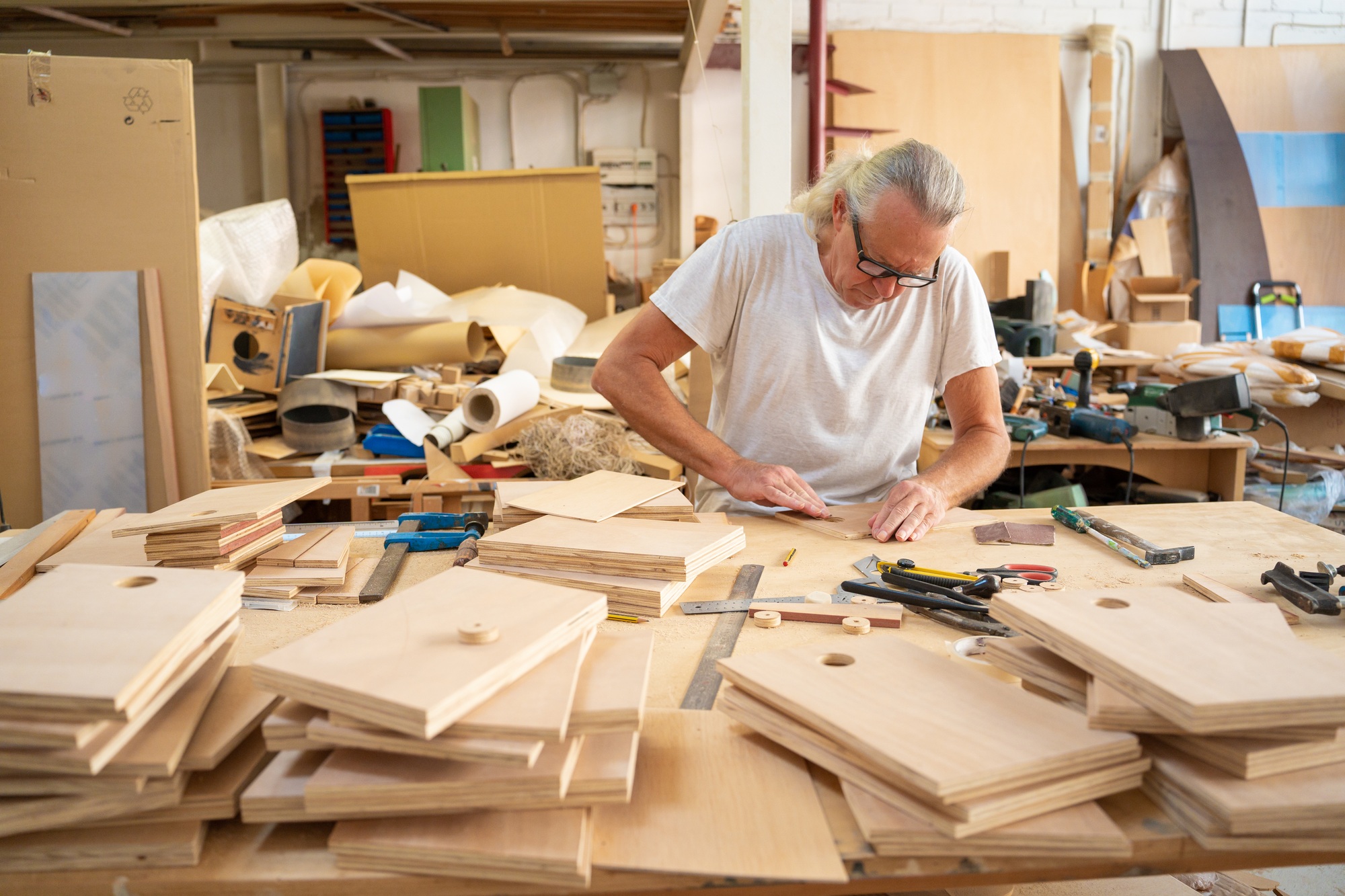 Carpenter working at workspace producing handmade wooden crafts.