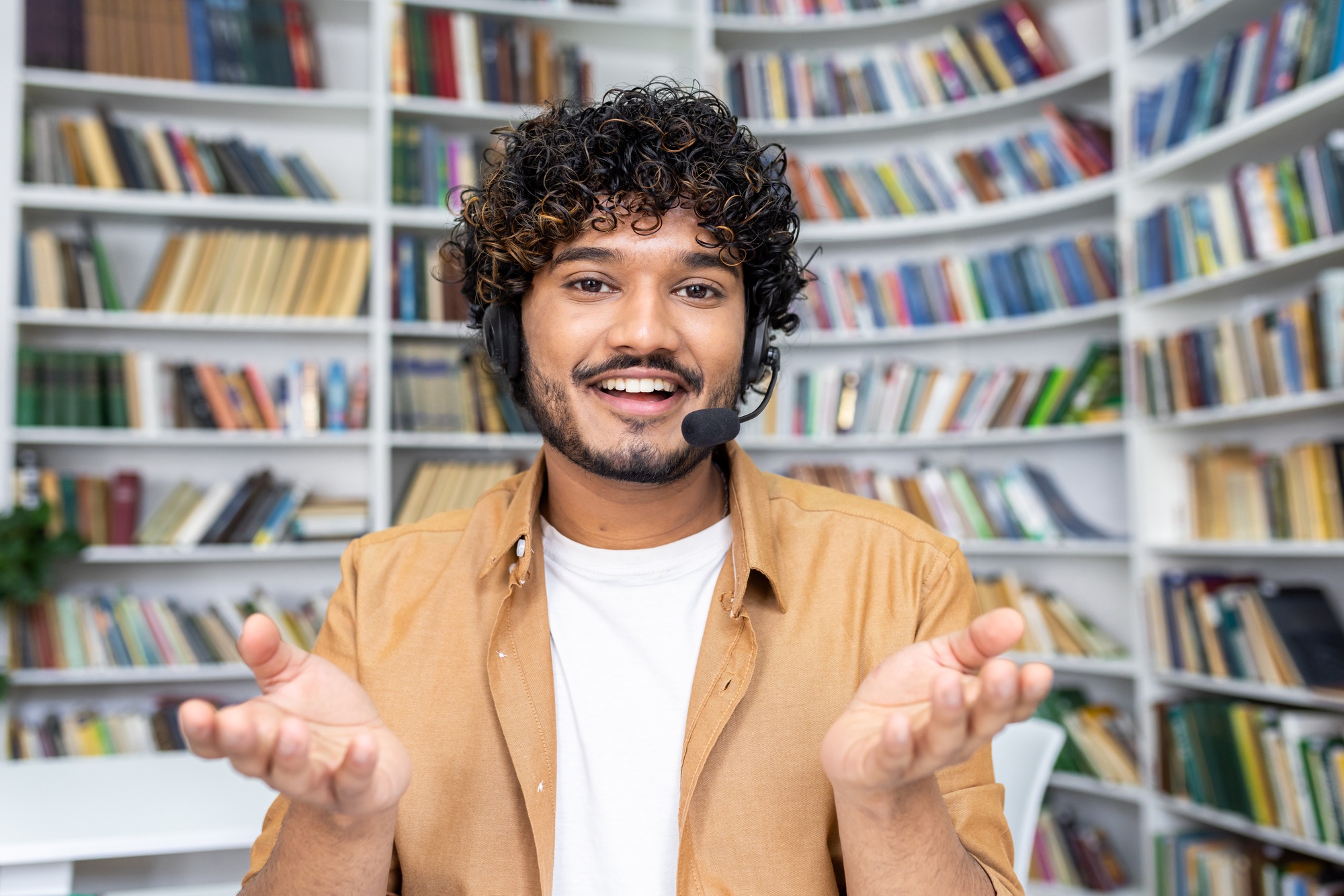 Casual man with outstretched hands in a library, concept of choice and decision making