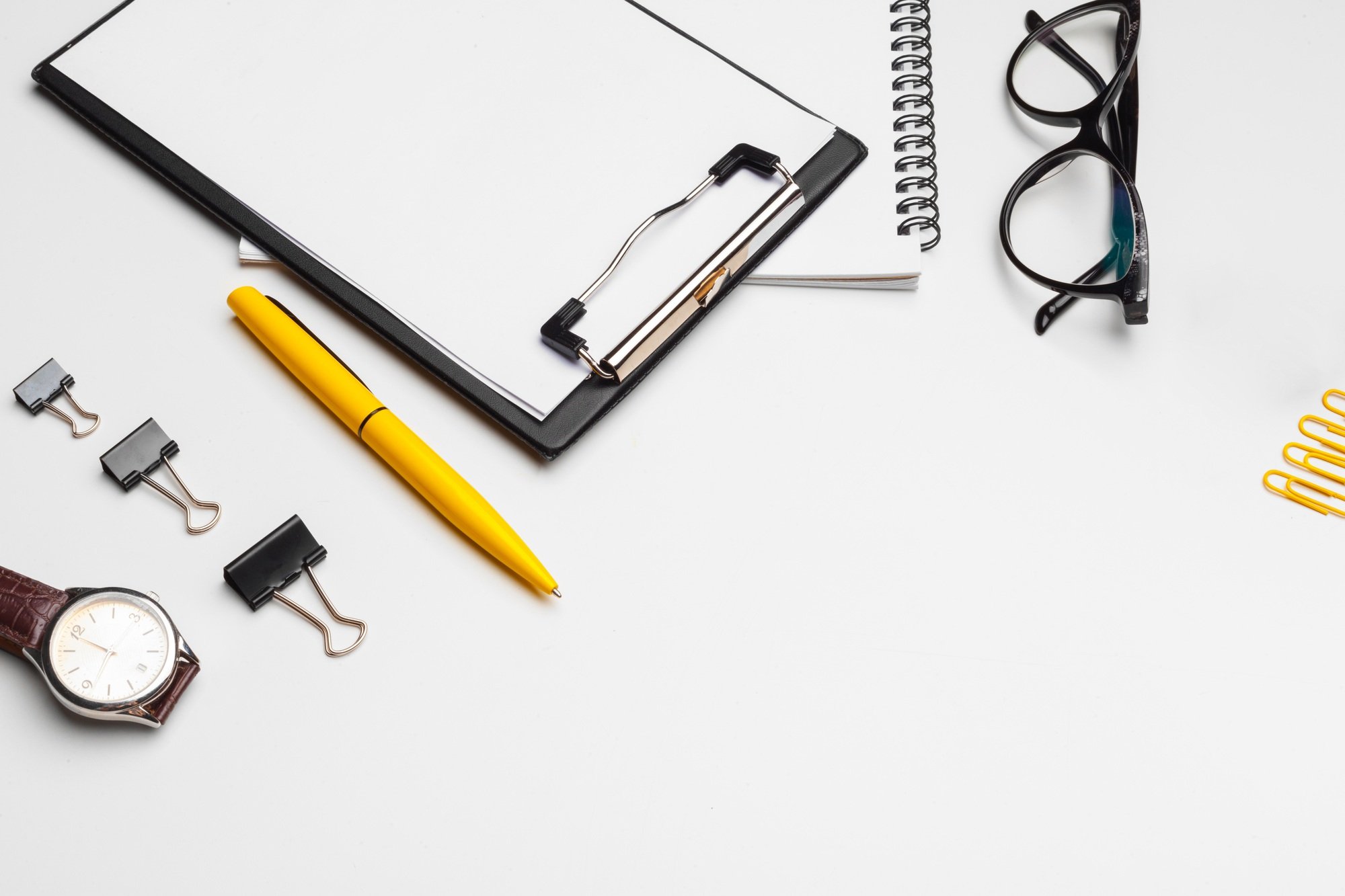 Clipboard with white sheet and pen isolated on a white background. Top view