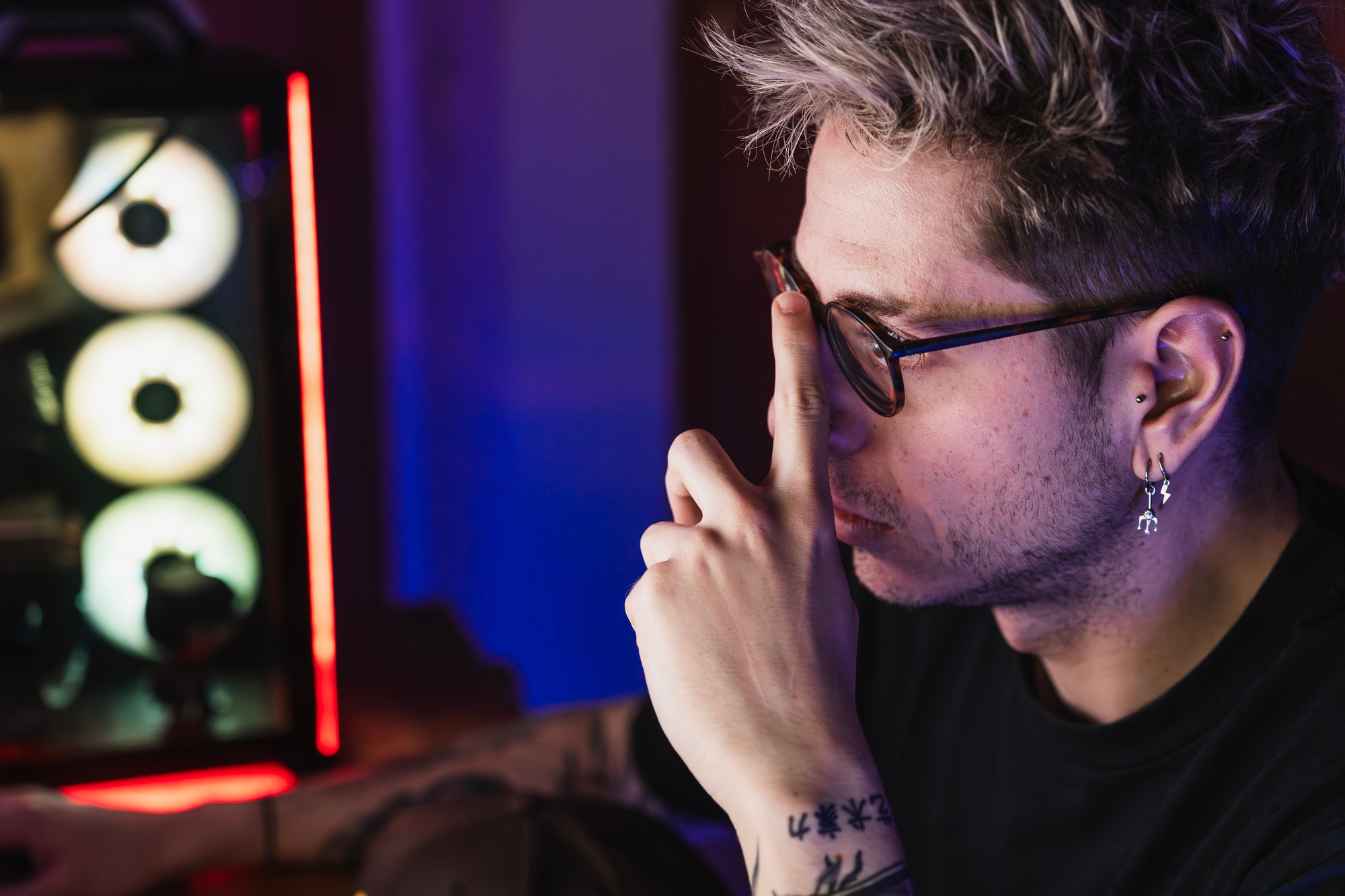 Close-up of a professional editor with glasses working in front of his computer screen