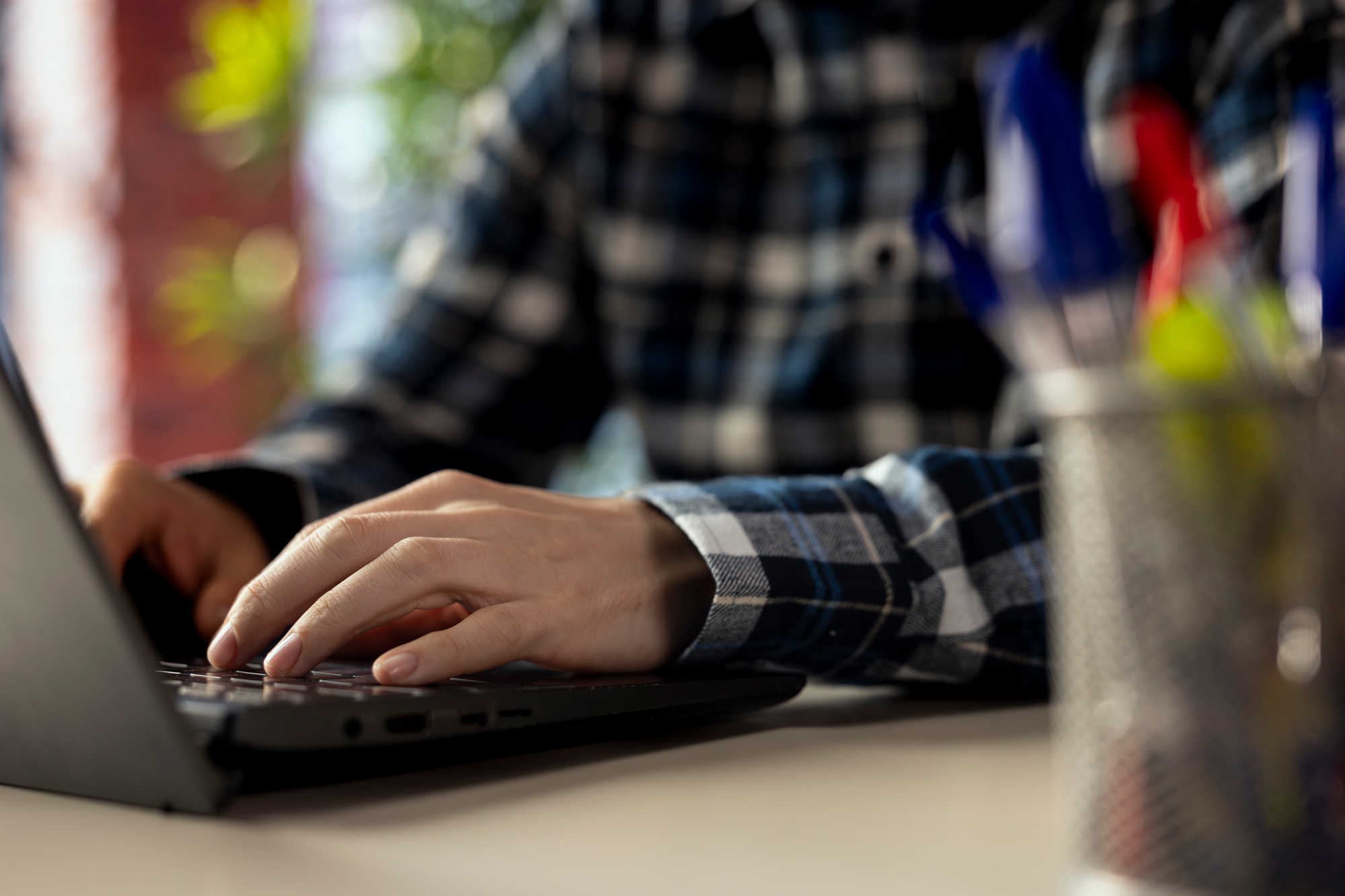 Close up of man at desk completing spreadsheets on notebook