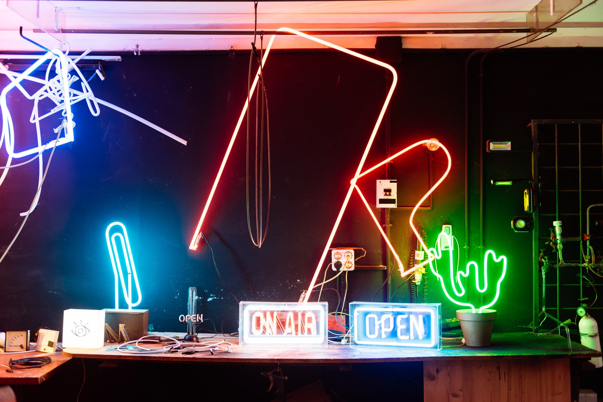 Colorful Neon Signs Illuminate A Workshop Space
