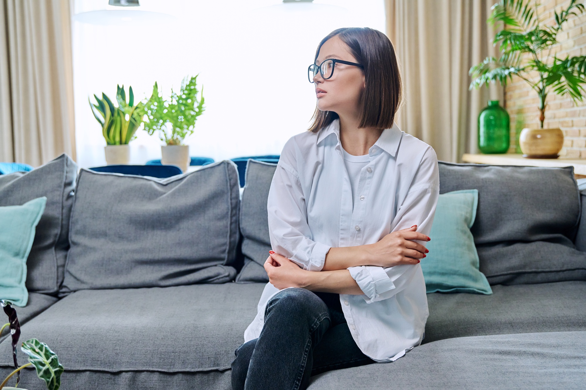 Confident young woman looking to side, profile view, in living room