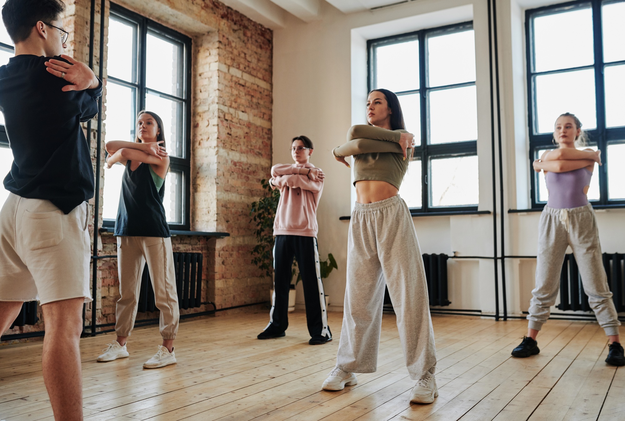 Contemporary teens standing in front of vogue dancing instructor during training