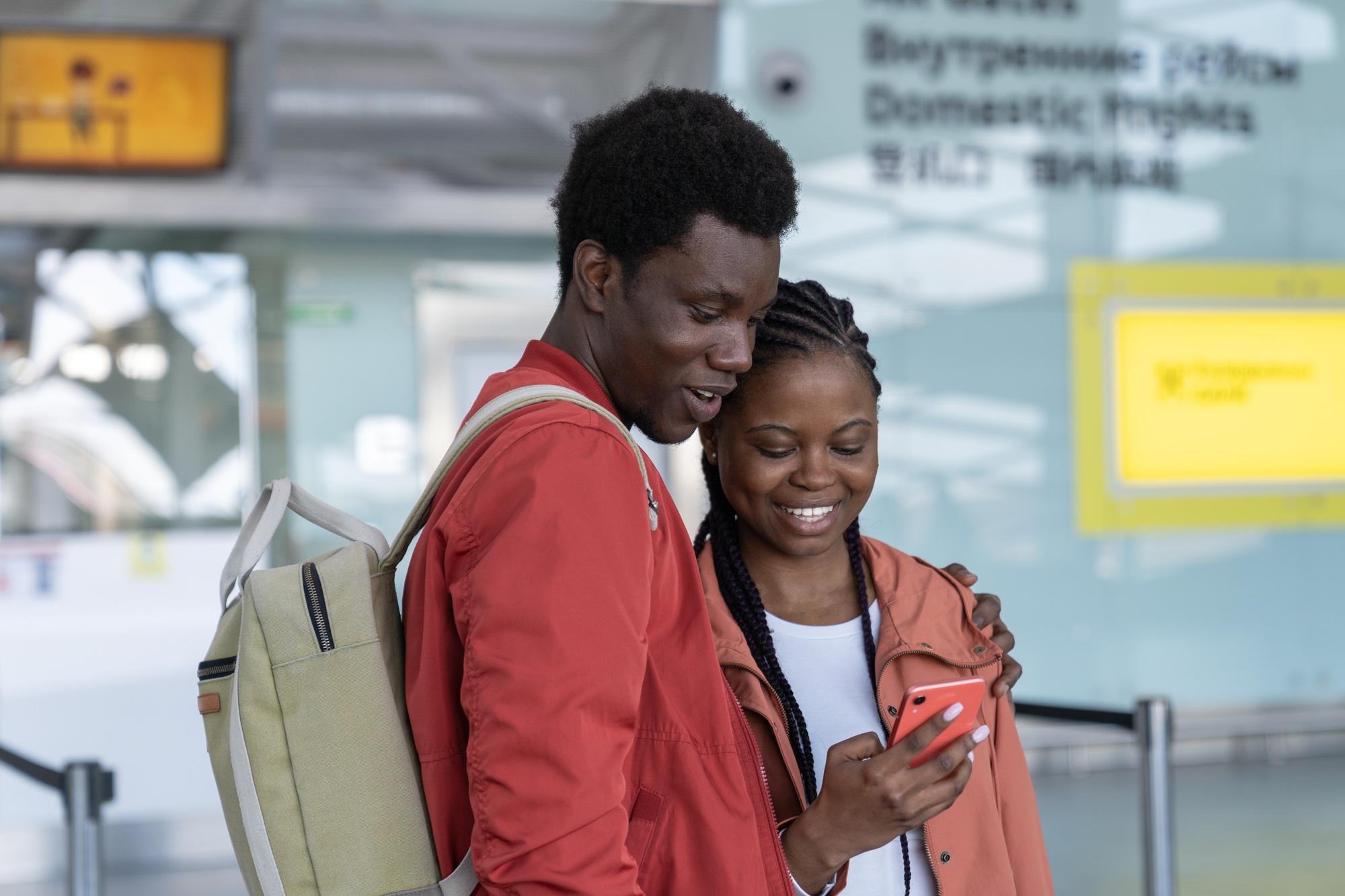 Couple of tourists in airport use mobile phone for online check-in wait first flight after covid end