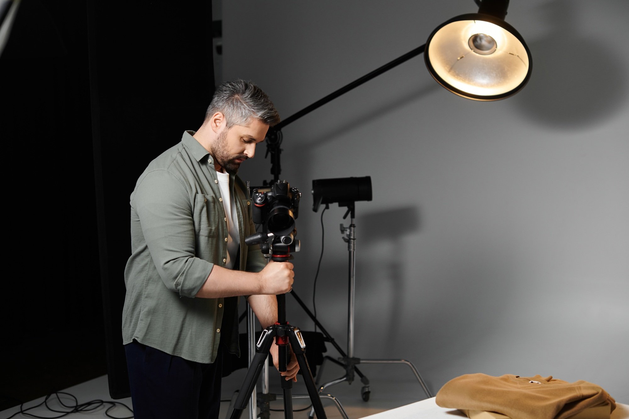 Creative man capturing details with camera in studio setup during professional session