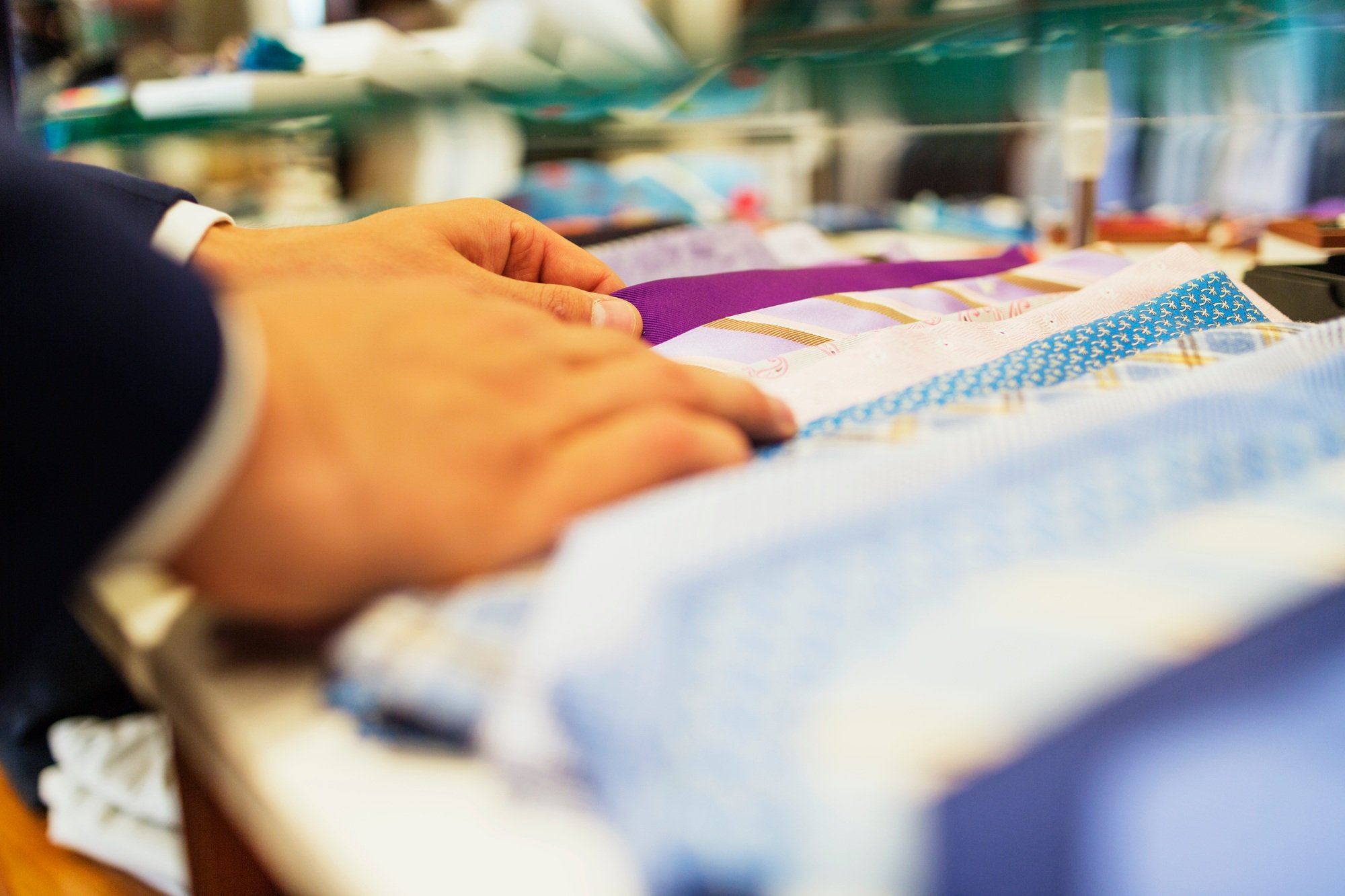 Cropped image of customer choosing neckties in clothing store