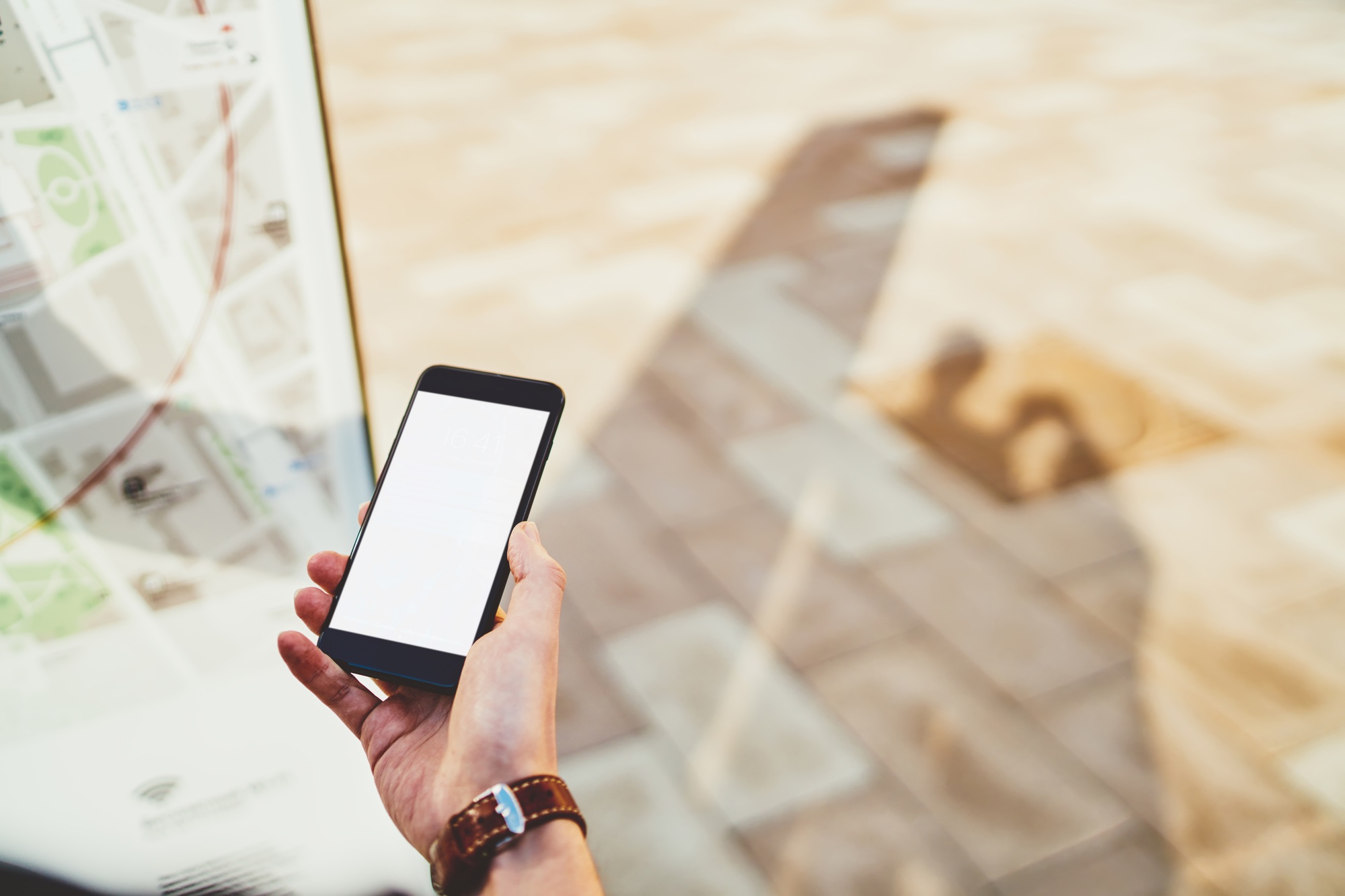 Cropped image of male hand holding smartphone with mock up screen copy space area for advertising