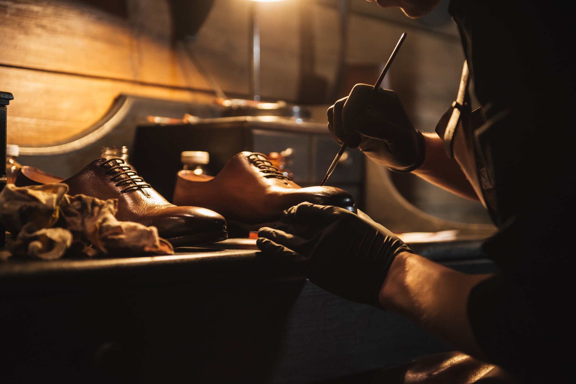 Cropped image of young concentrated man shoemaker
