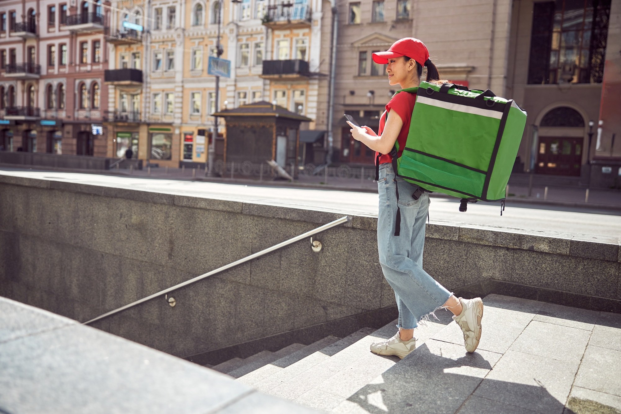 Delivery service worker carrying food order on city street
