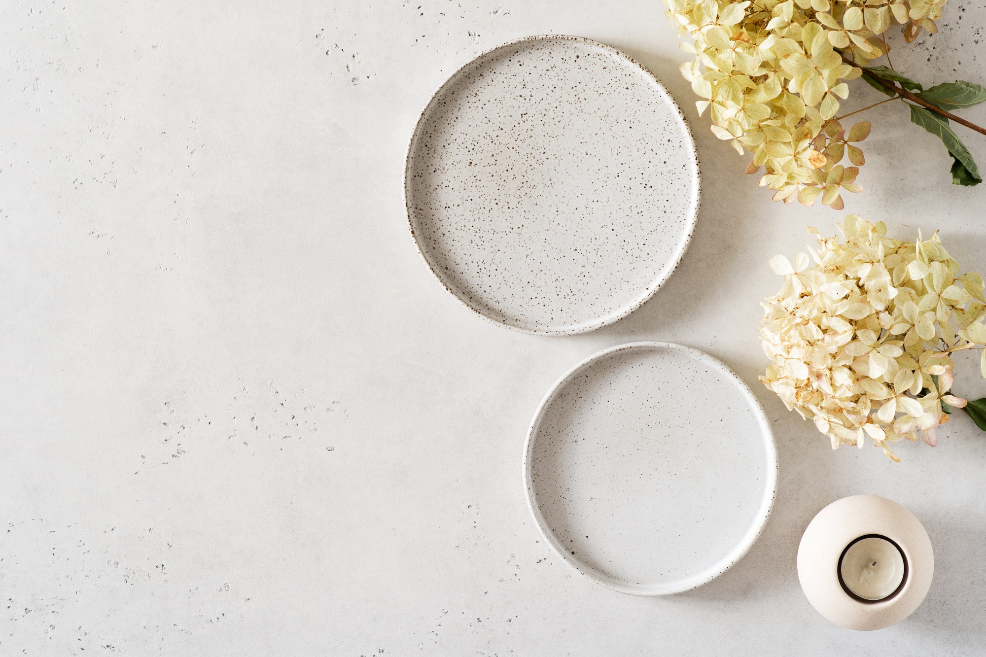 Empty craft handmade ceramic grey plates and flowers