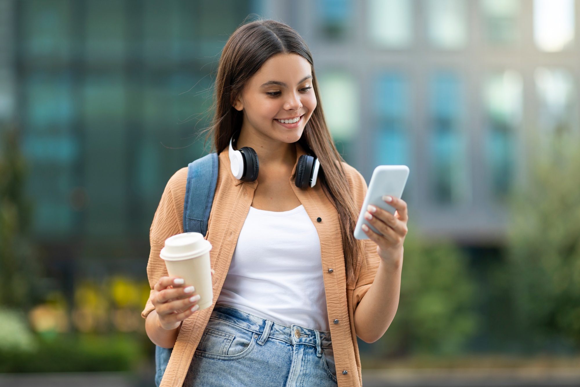 Engaged young woman student shopping online, sunny campus