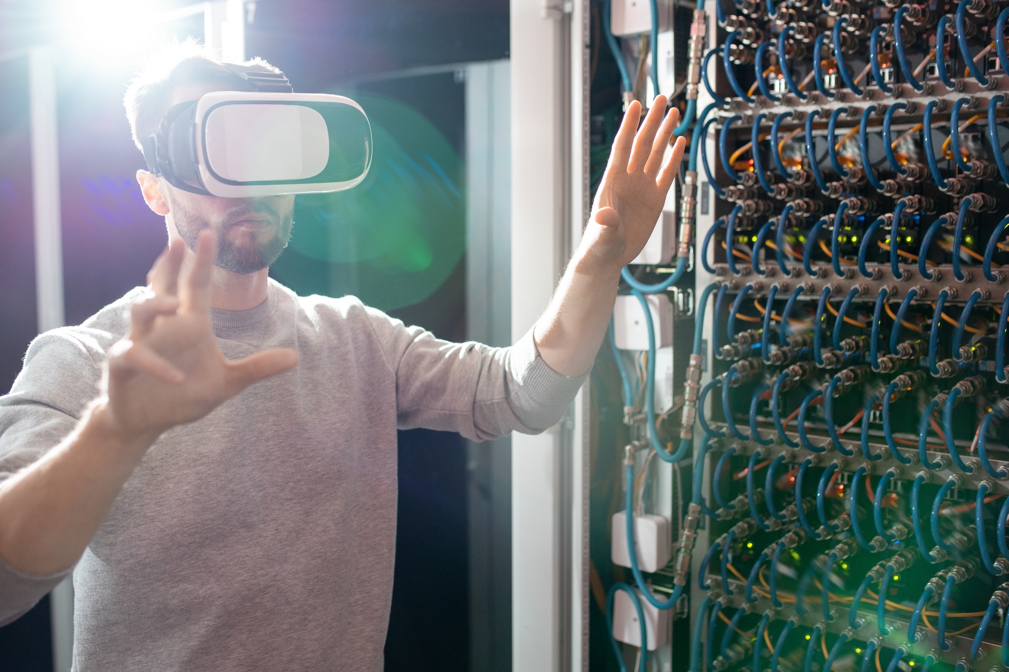 Engineer in VR goggles working in database center