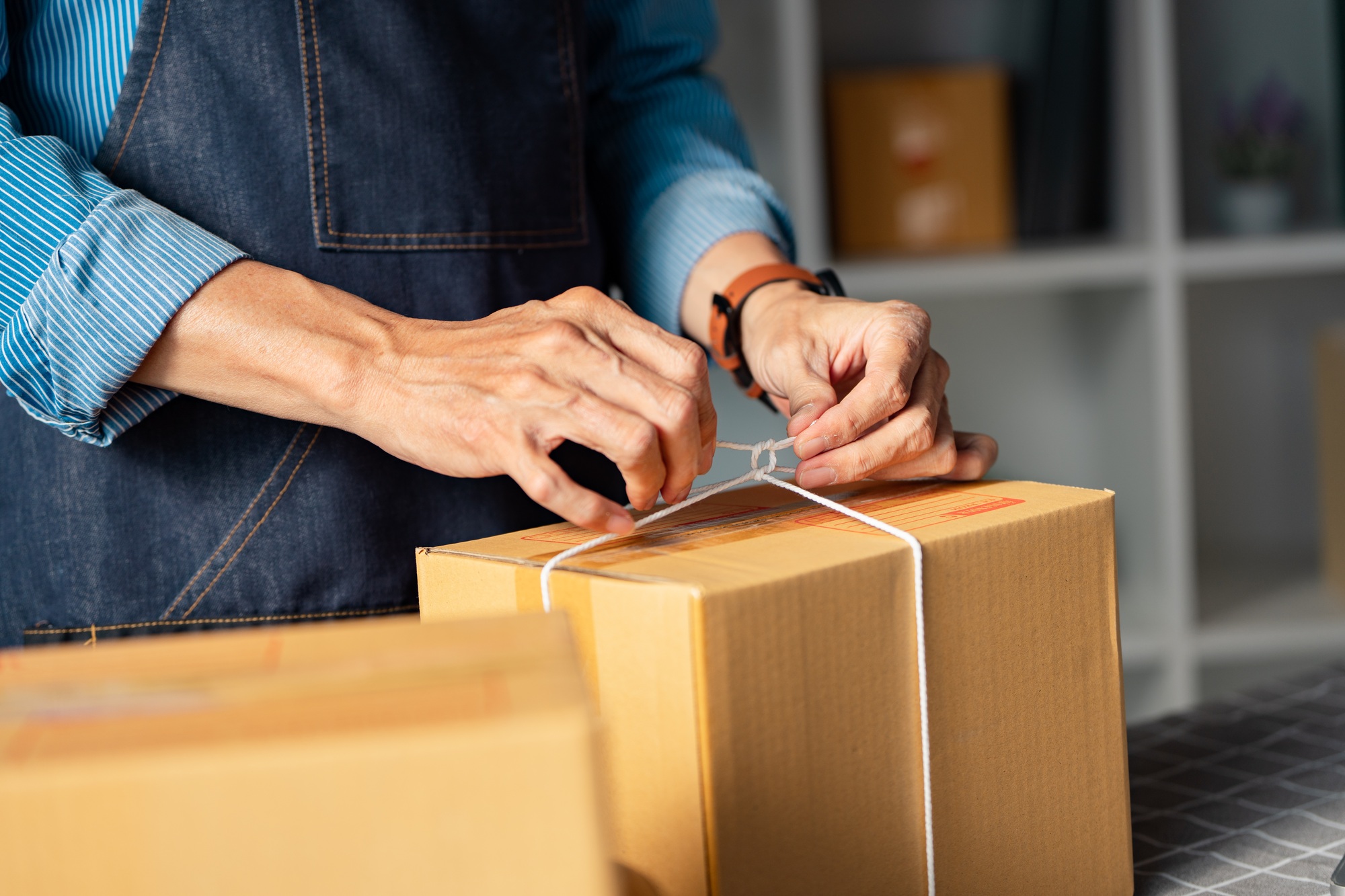 Entrepreneur packaging products for online sales, focusing on detail and quality control.