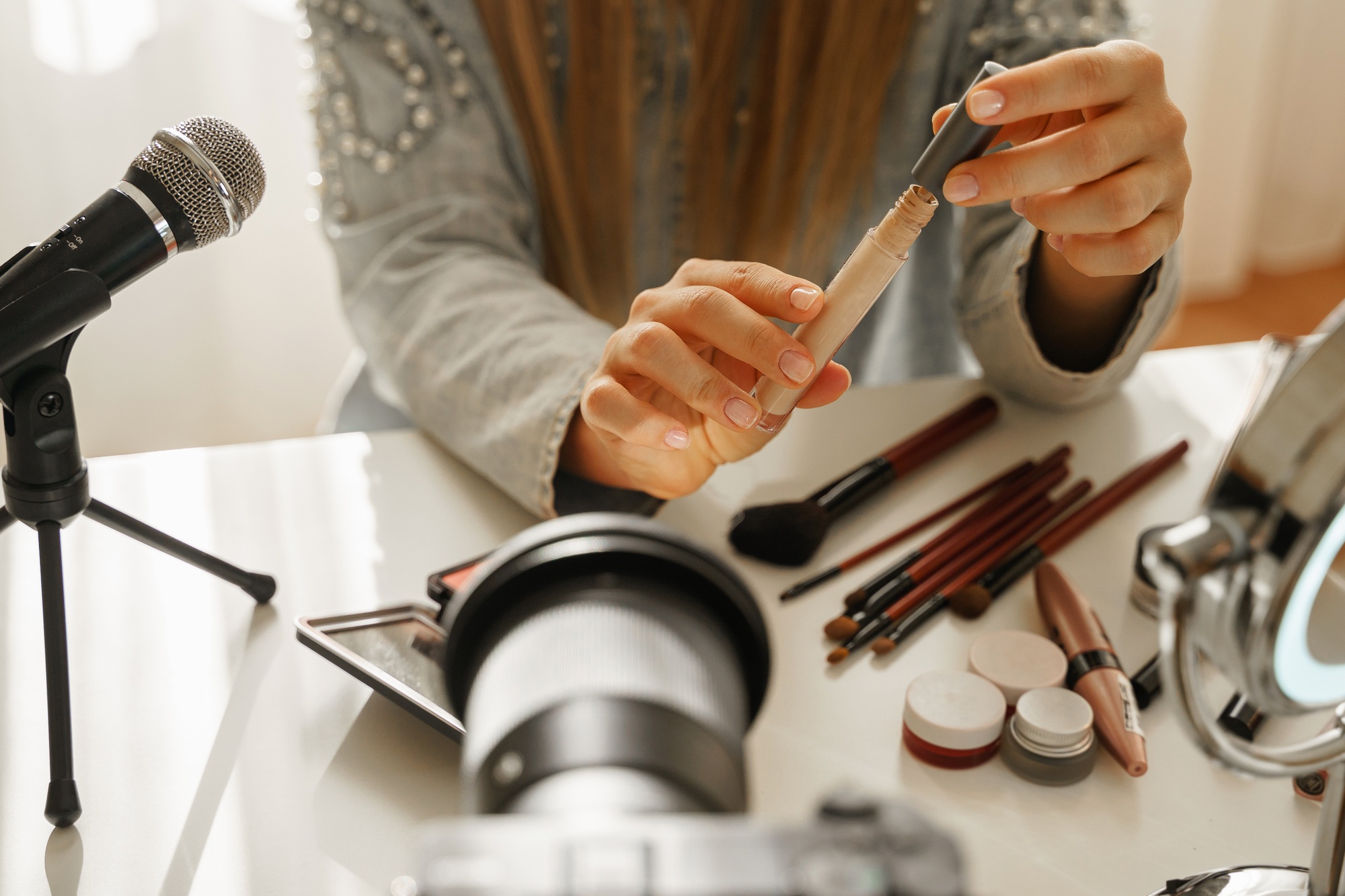 Female hands with a liquid concealer. Beauty blogger making a video review of cosmetic products.