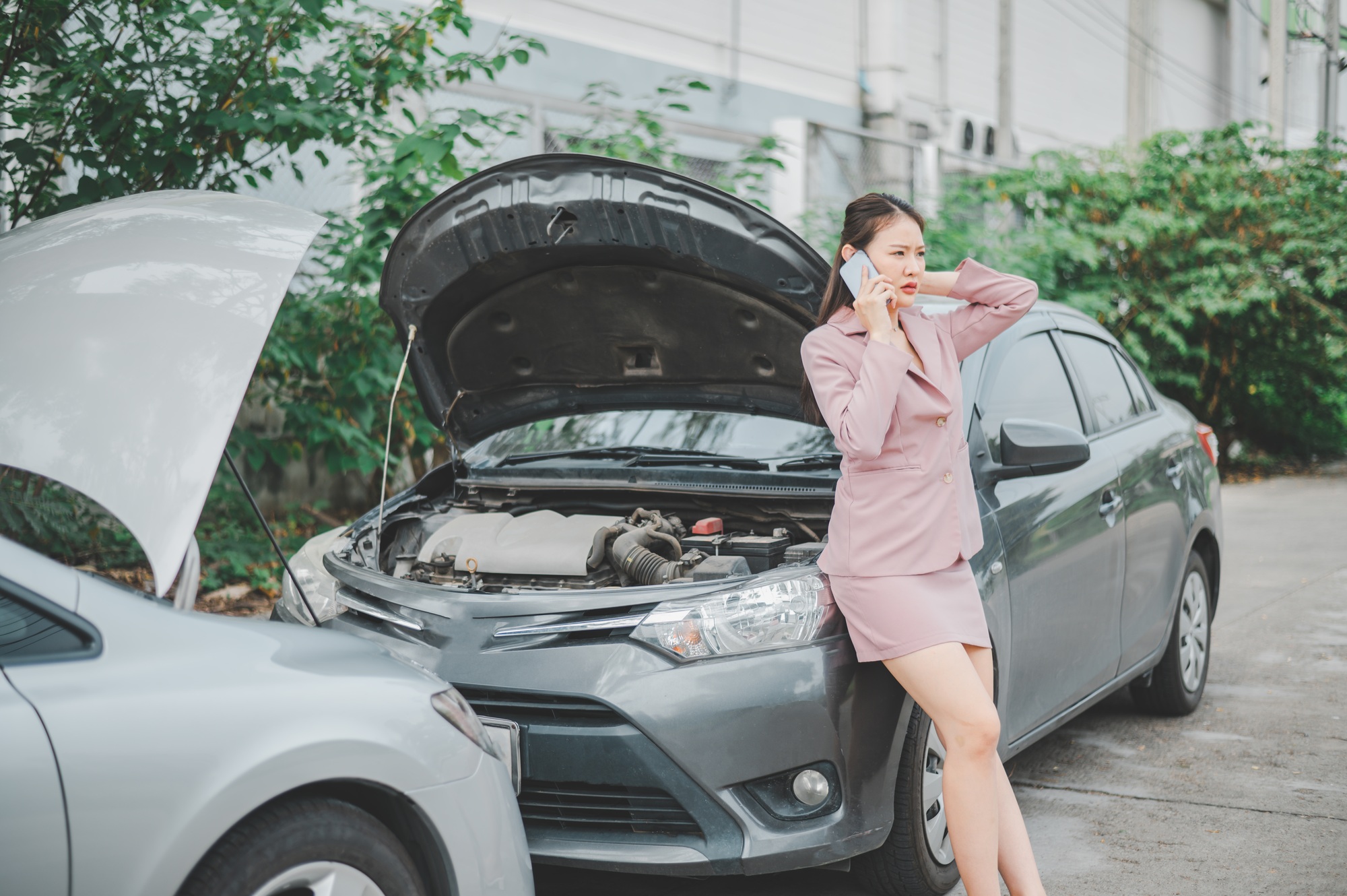 female motorist is calling an insurance or recovery service officer for assistance
